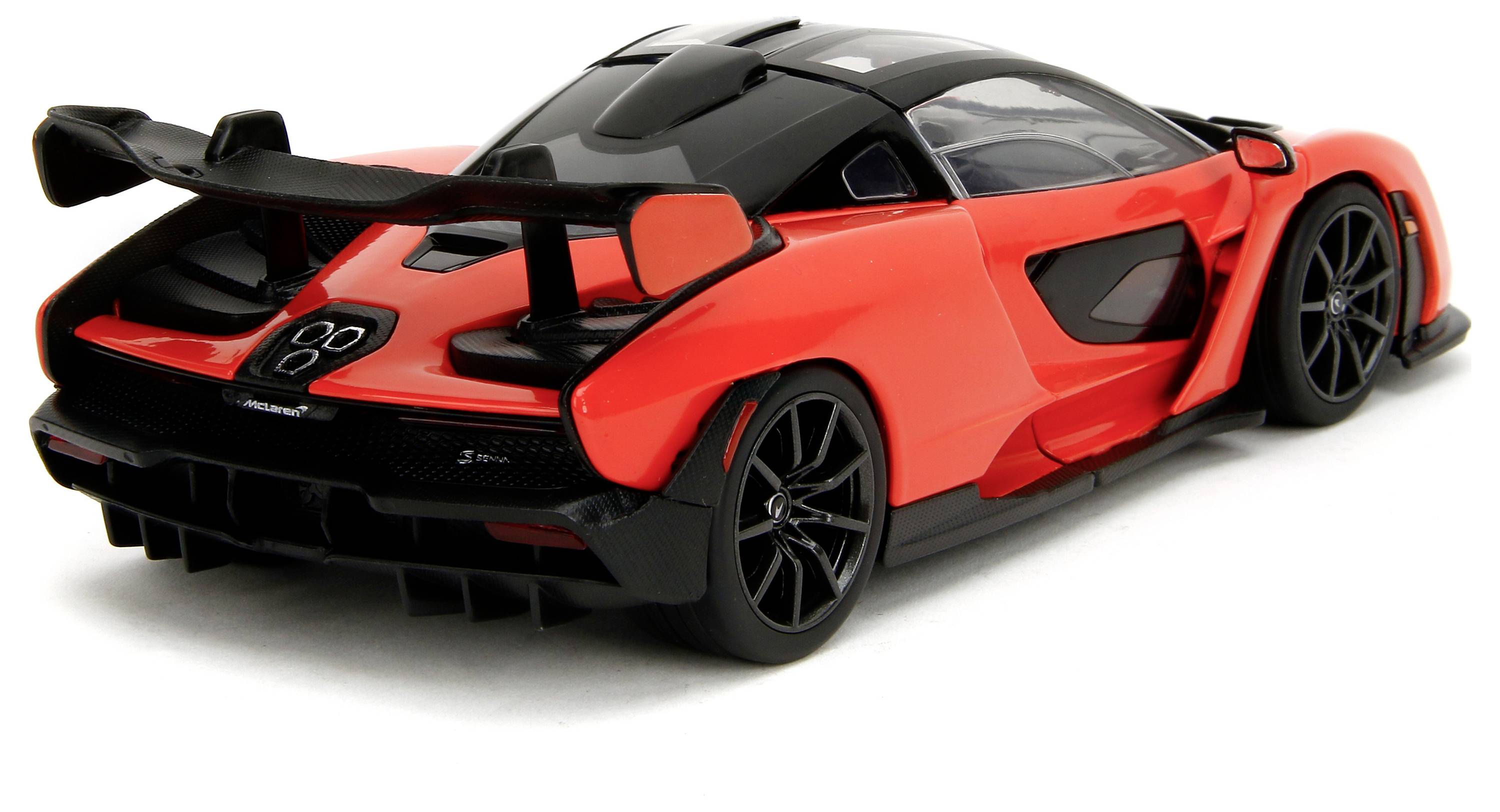 Červený sportovní vůz s černou střechou a velkým zadním křídlem, fotografovaný zezadu z boku. Dynamický design a aerodynamický tvar.