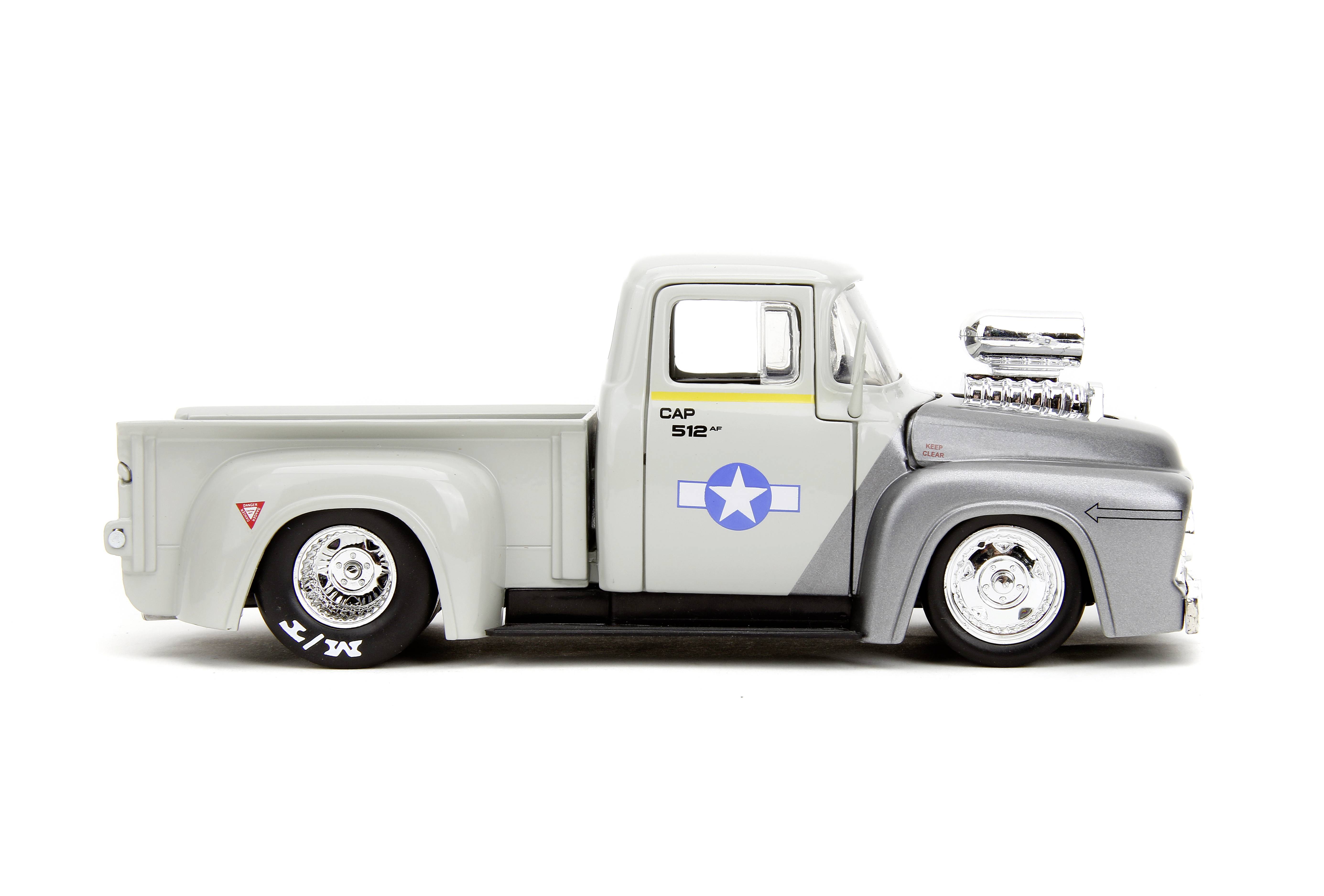 Šedý a stříbrný modelový nákladní vůz s velkým motorem a hvězdným symbolem na dveřích, pohled z boku.