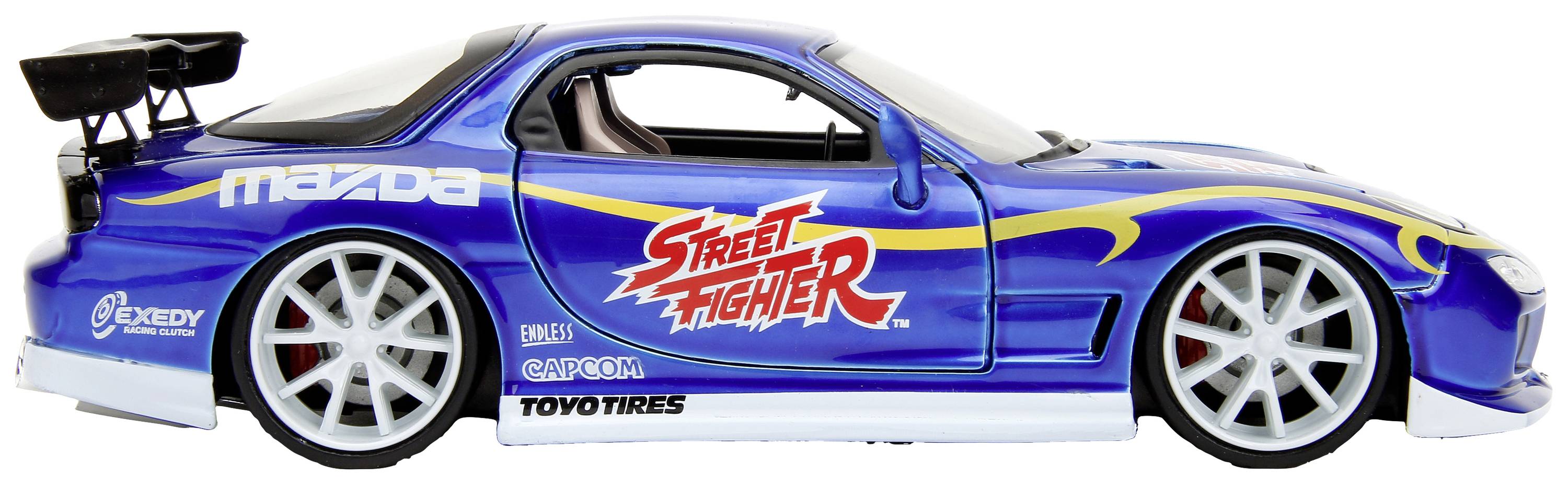 Modré modelové auto s logem 'Street Fighter' na boku. Nápadný spoiler, velká kola. Viditelná značková loga Mazda a Toyo Tires.