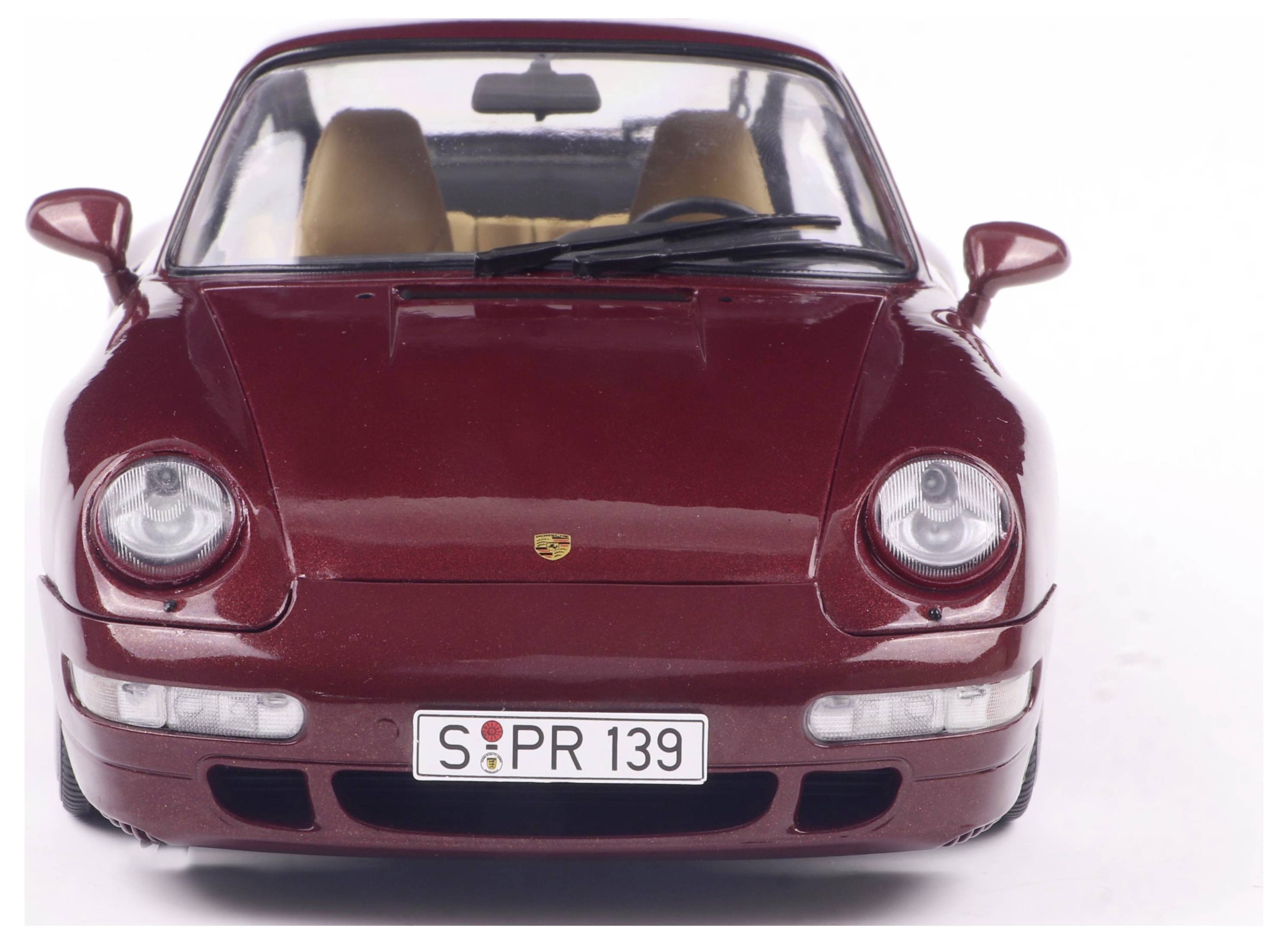 Červený sportovní vůz zepředu s reflektory a registrační značkou 'S PR 139'. Interiér s béžovými sedadly je viditelný.