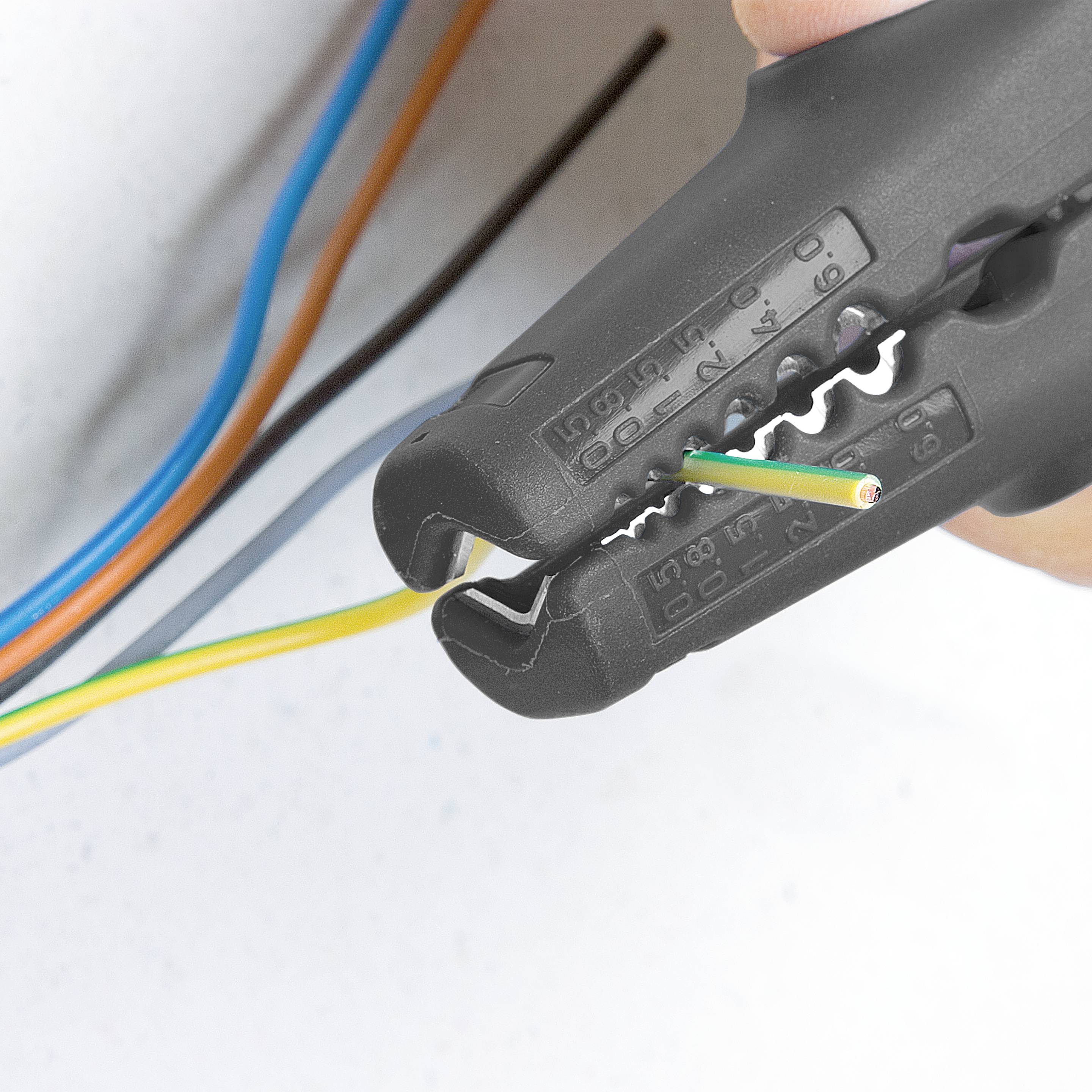 Kleště na krimpování stahují izolaci z vícebarevného elektronického kabelu.