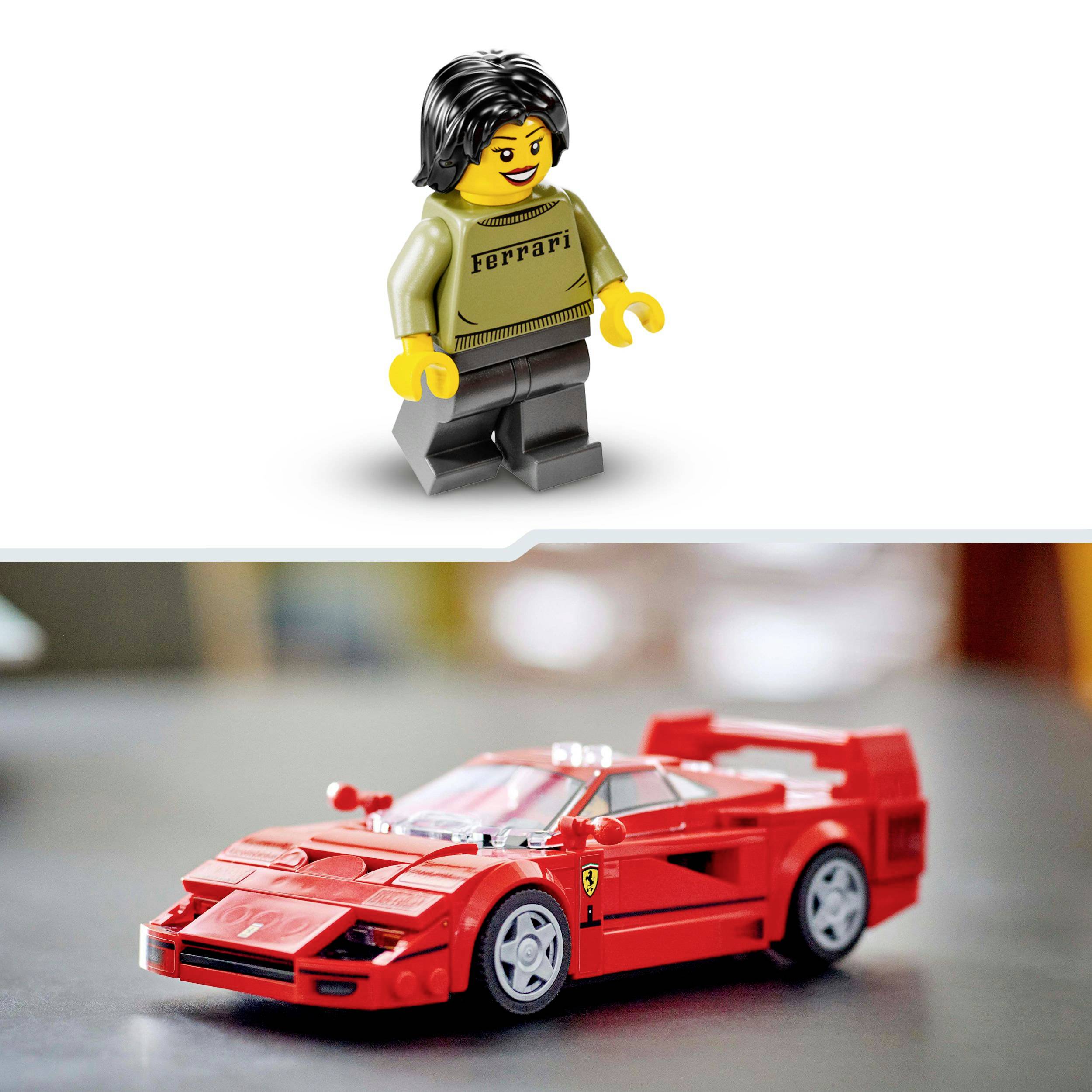 Postavička LEGO oblečená ve stylu Ferrari stojí vedle červeného hračkového auta značky Ferrari na hladkém, rozmazaném povrchu.