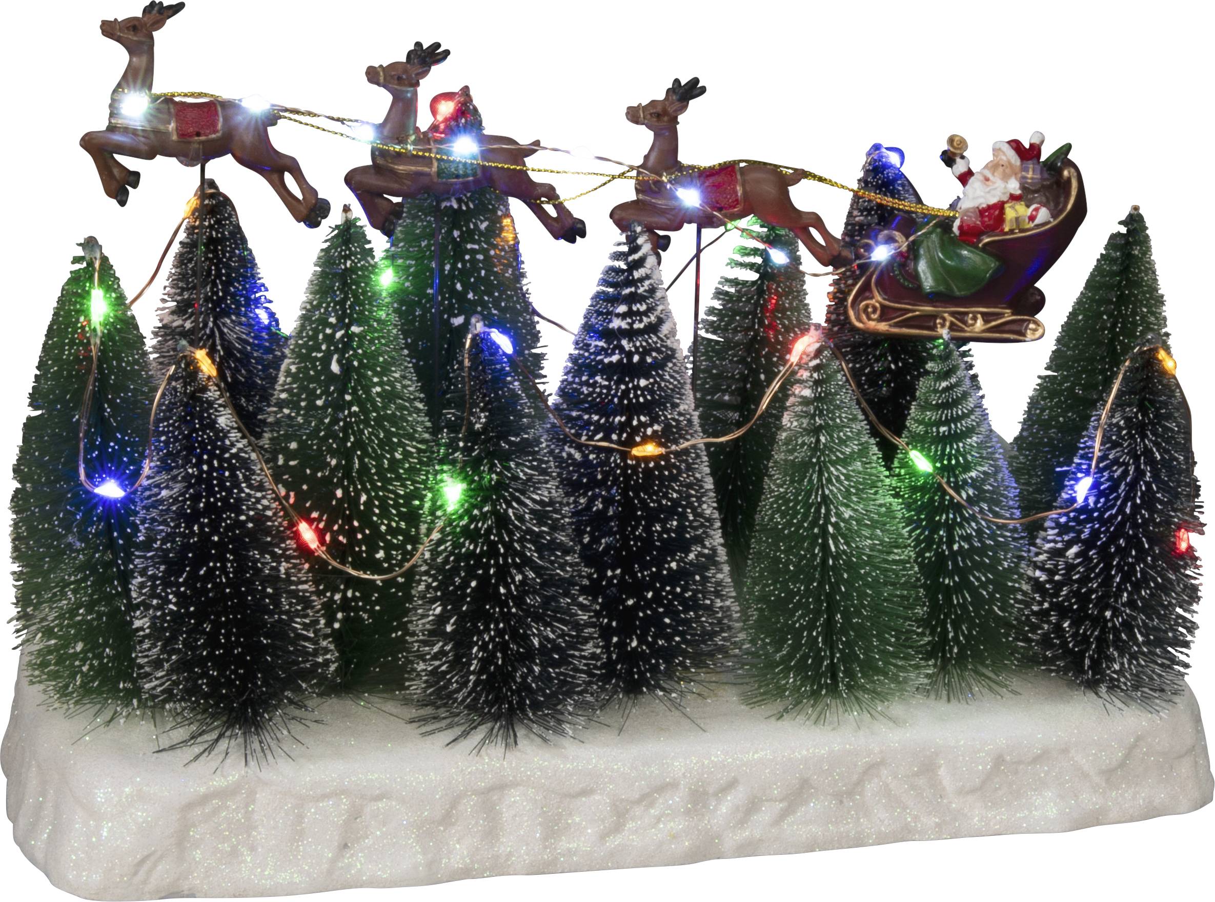 Vánoční scéna s osvětlenými miniaturními vánočními stromky. Nahoře letí saně tažené soby, ve kterých sedí Santa Claus s dárky.