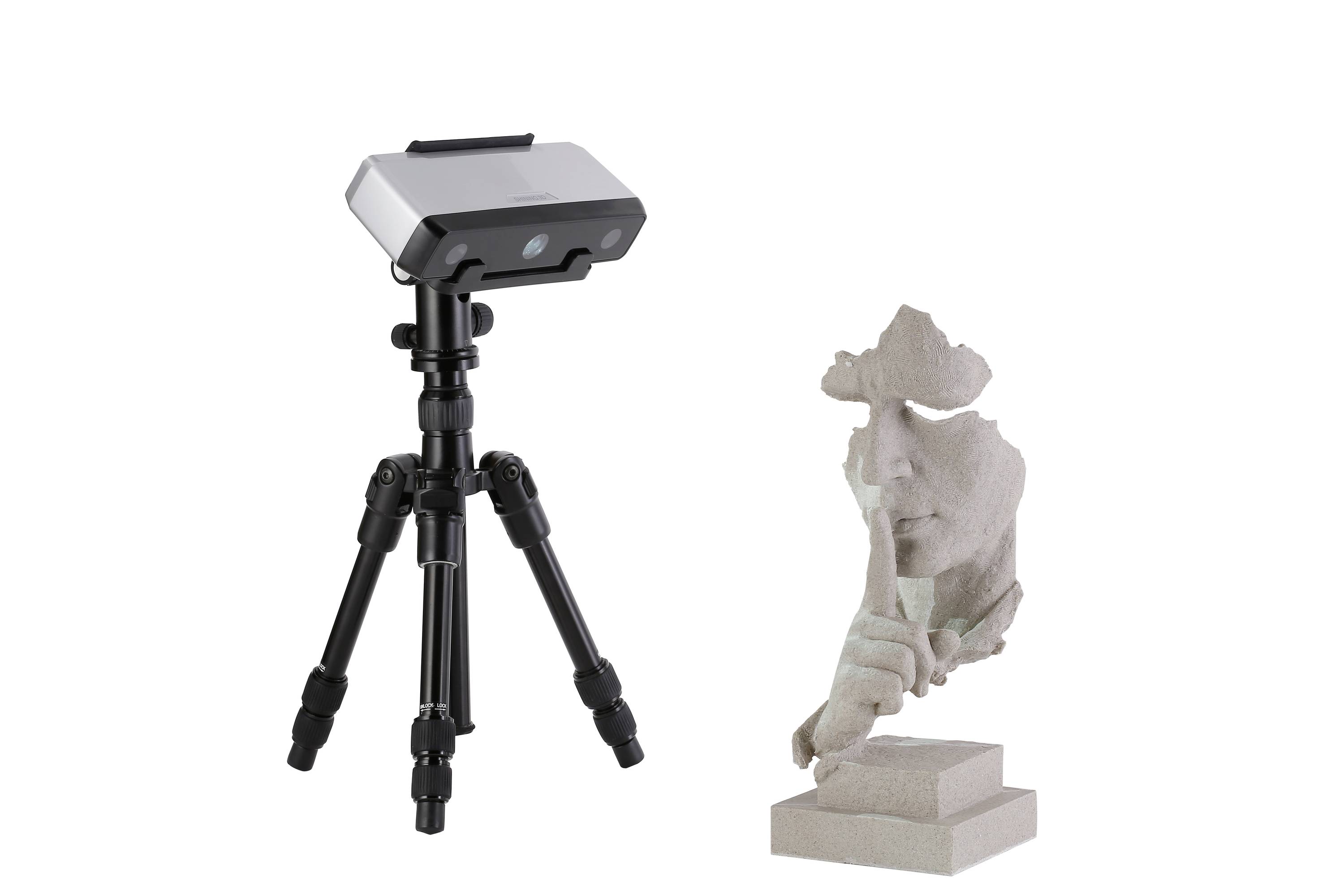 3D skener na stativu vedle fragmentované sochy obličeje s prstem přiloženým na rty.