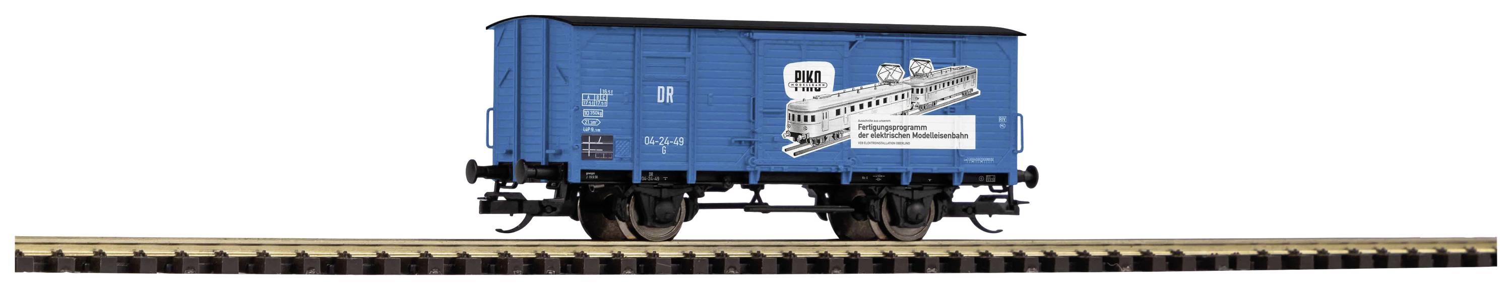 Modrý modelový nákladní vůz na kolejích, s černobílou reklamou na vlak Rheingold, historickou železnici.