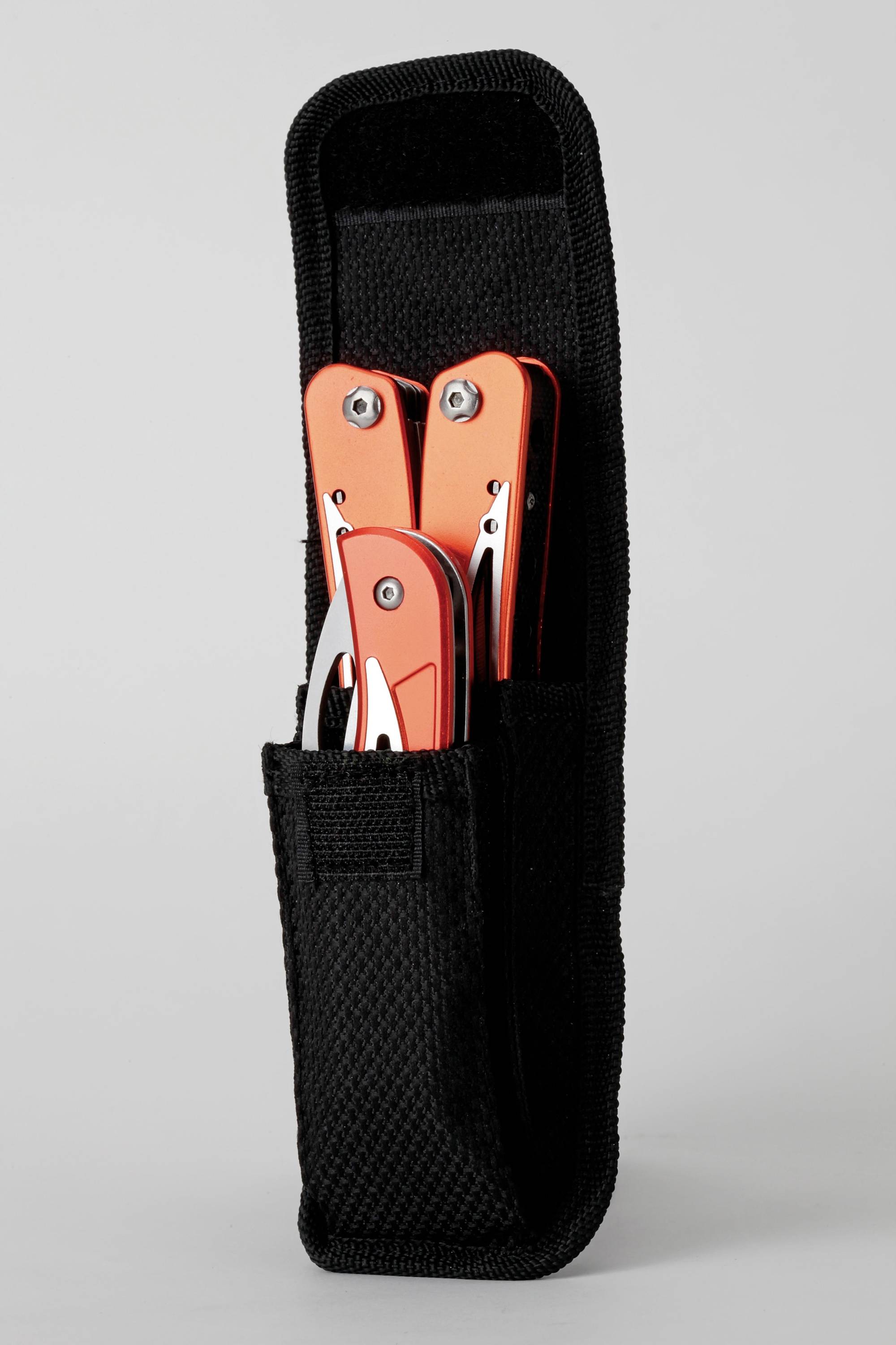 Červený multifunkční nástroj v černém textilním pouzdře. Nástroje jsou částečně viditelné a ukazují kovové komponenty.