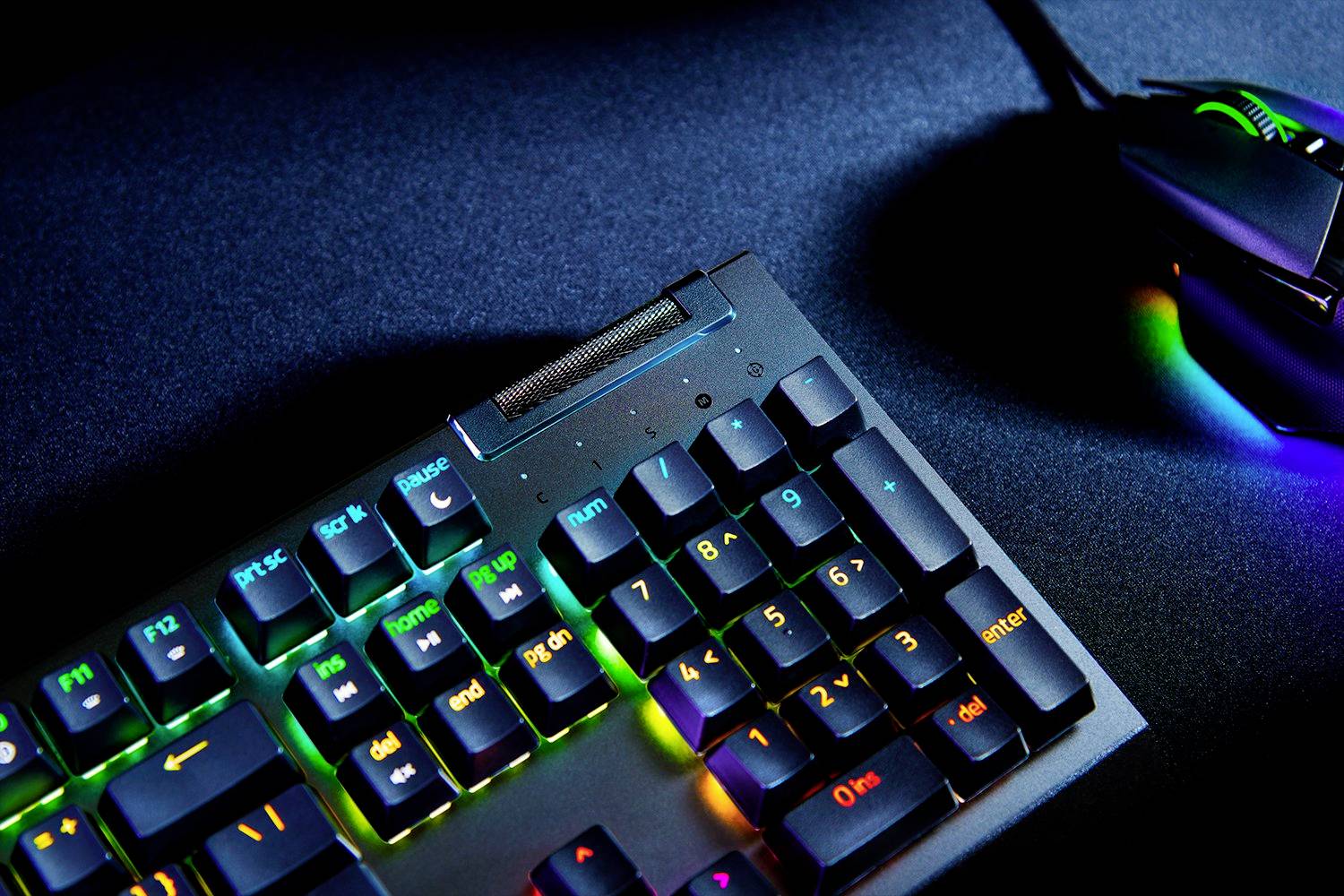 Klávesnice s RGB podsvícením vedle osvětlené myši na tmavém pozadí.