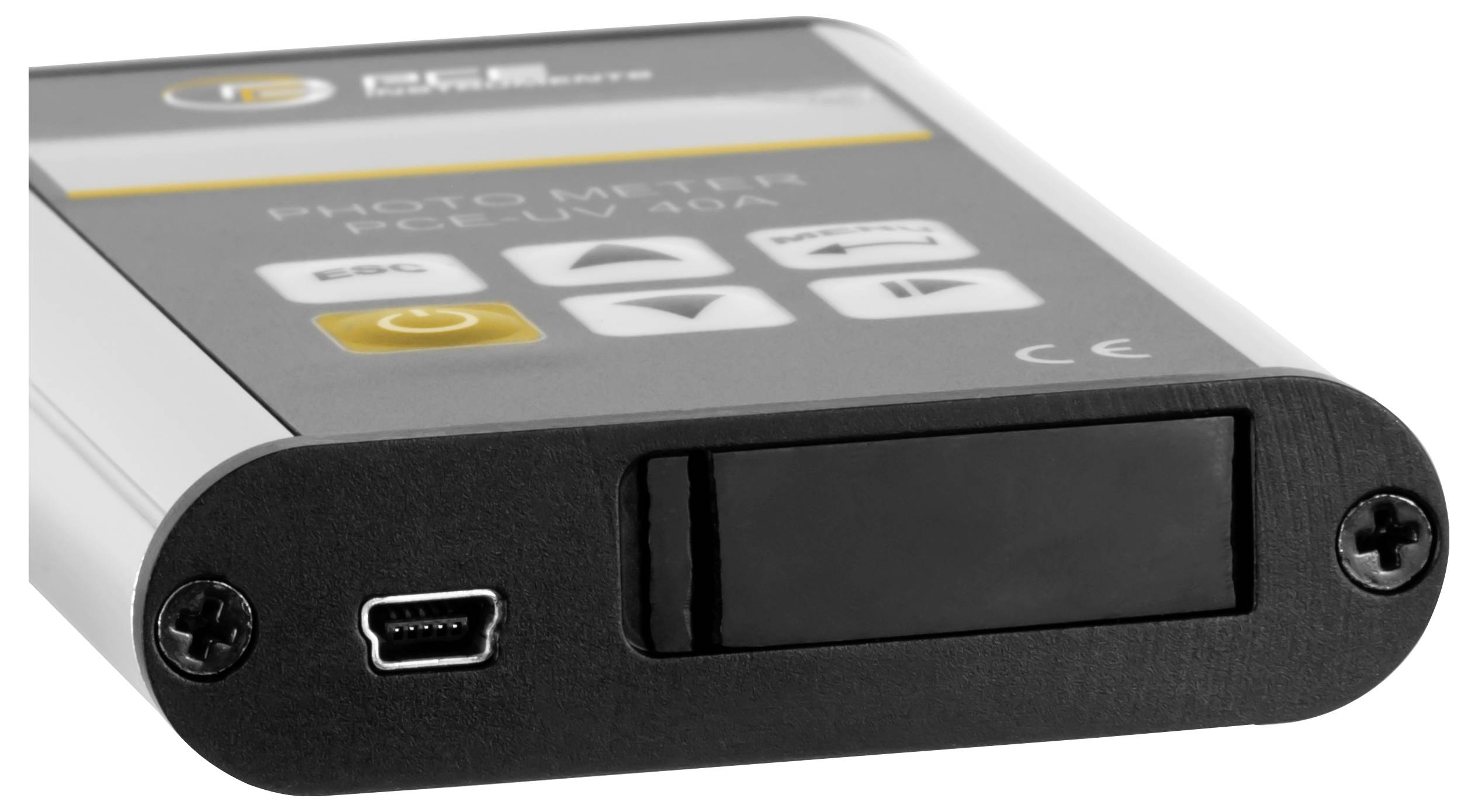 Detailní pohled na přenosné ruční zařízení s černým předním panelem, zápustitou obrazovkou, portem micro-USB a vytisknými ovládacími tlačítky na horní straně.