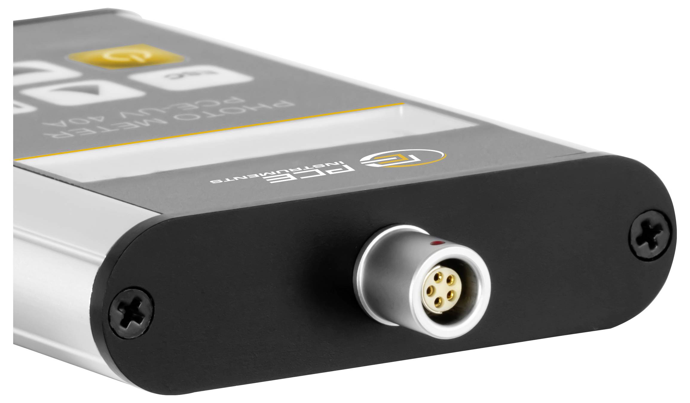 Zblízka stříbro-černého elektronického zařízení se čtyřkolíkovým kulatým konektorem na přední straně a viditelnými šrouby v pouzdře.