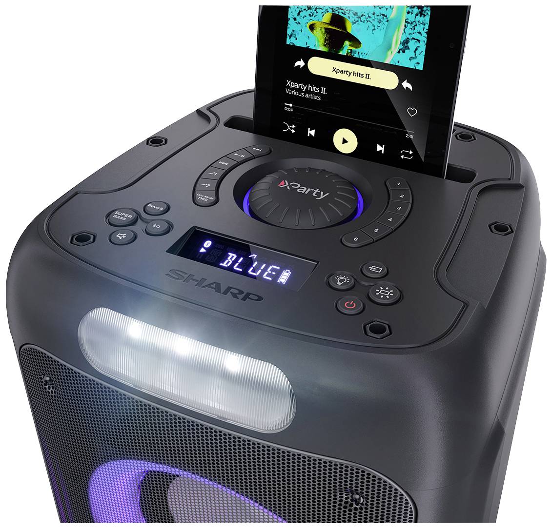 Přenosný reproduktor značky Sharp s vestavěným displejem zobrazuje ovládání hudby. Smartphone přehrává hudbu s titulem 'Xparty hits II'.