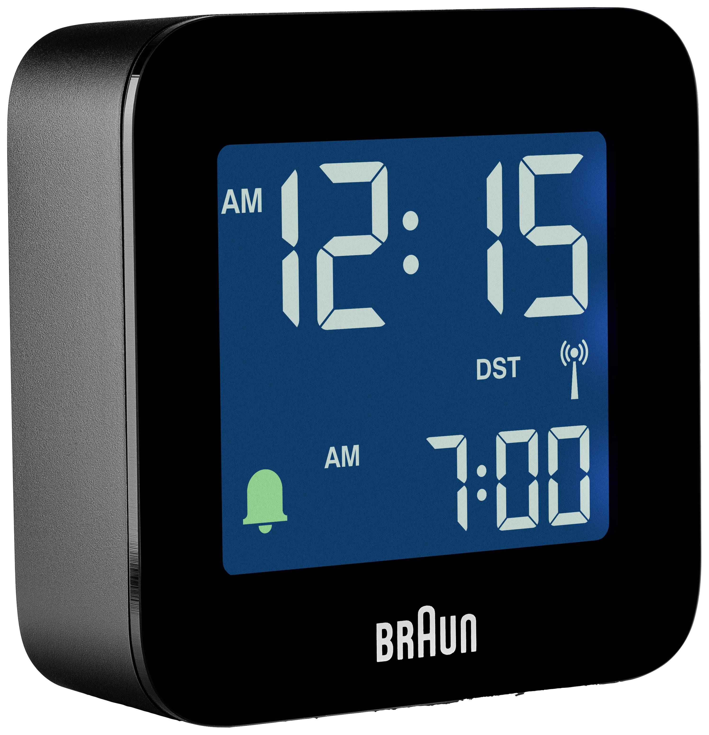 Černý digitální budík s podsvíceným displejem zobrazuje čas '12:15' a budíkovou dobu '7:00'. Označení pro letní čas.