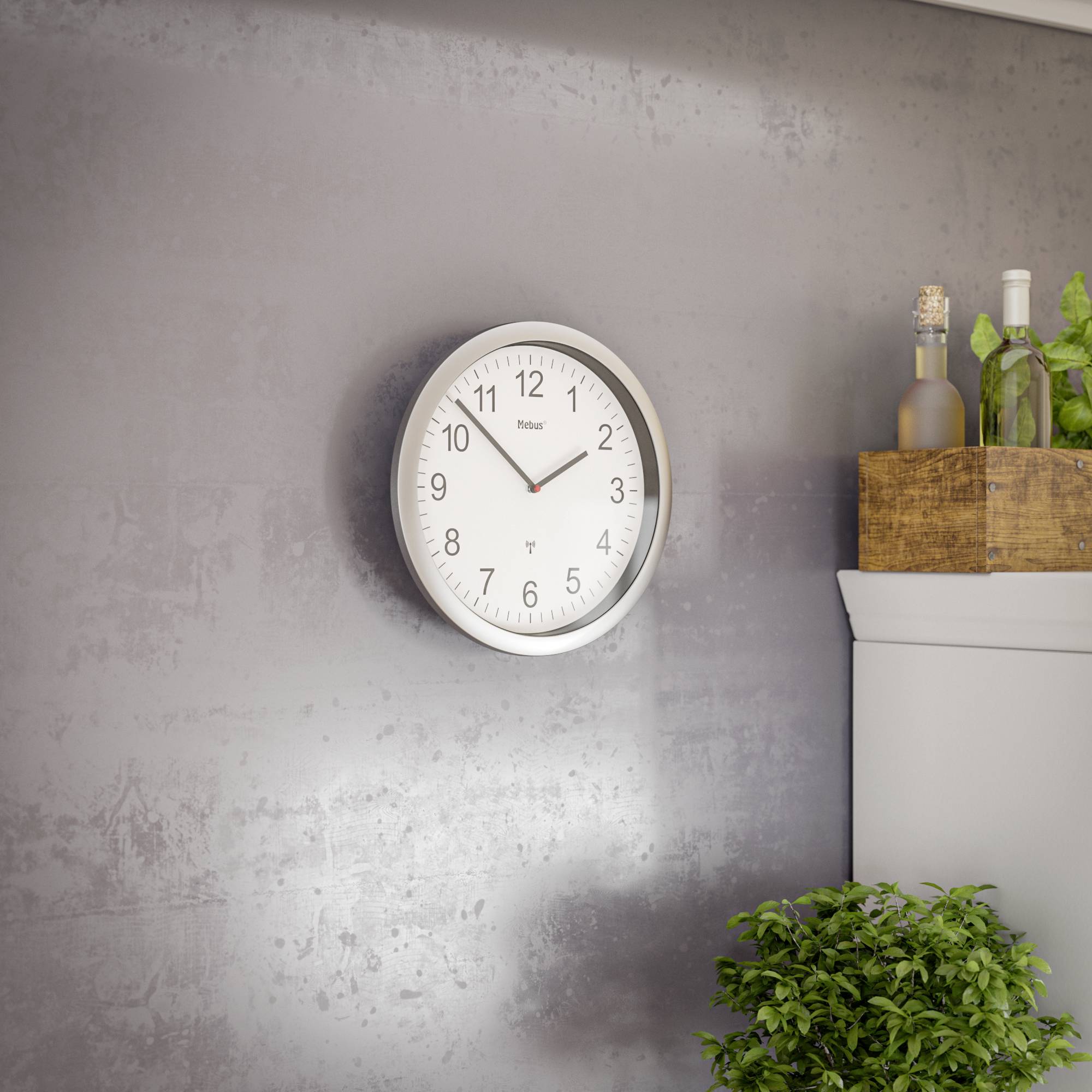 Nástěnné hodiny ukazují 10:10. Vedle nich stojí na poličce dřevěná krabice s zeeleným rostlinstvem, včetně kulaté vázy.