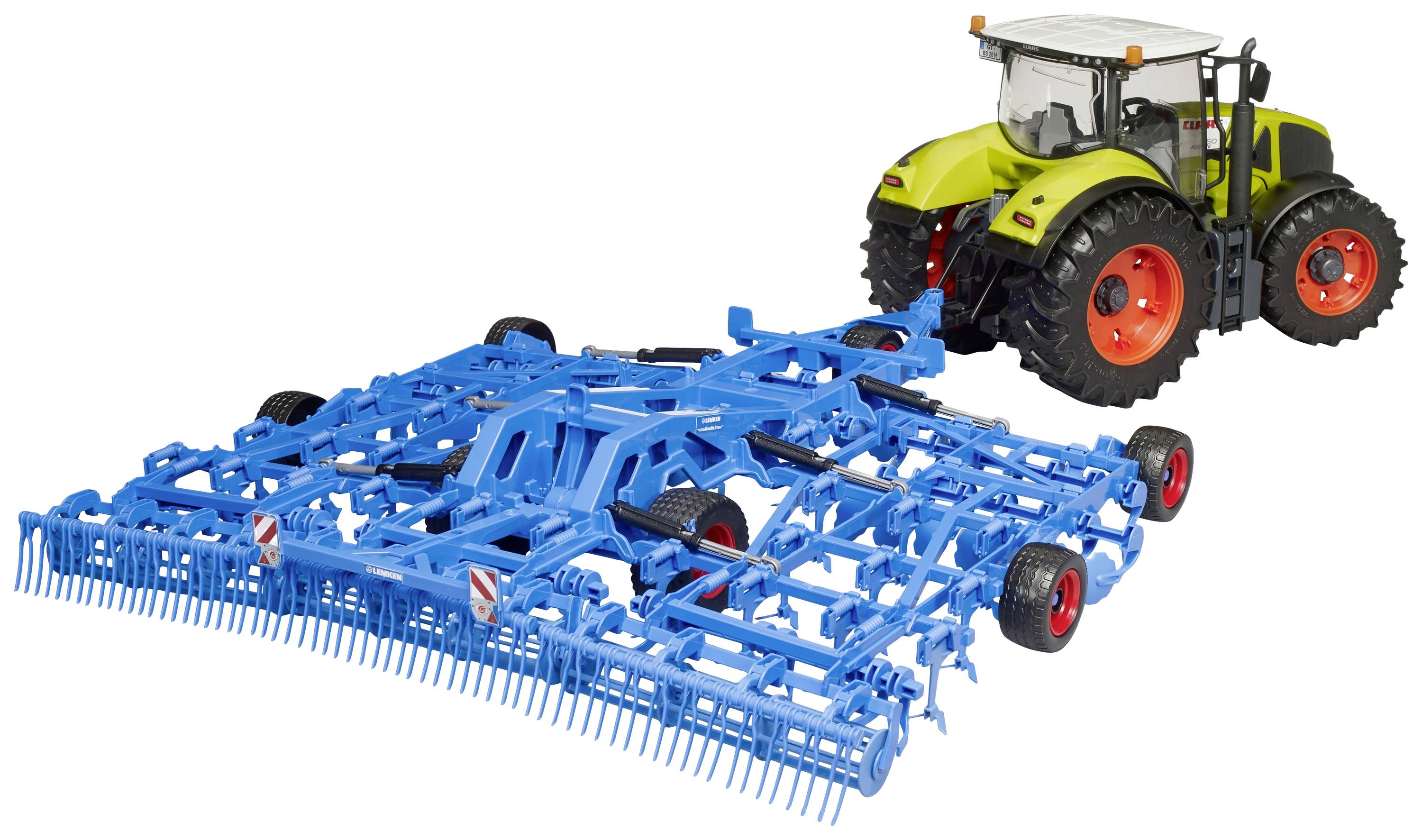 Zelený traktor táhne velké modré zemědělské zařízení přes pole.