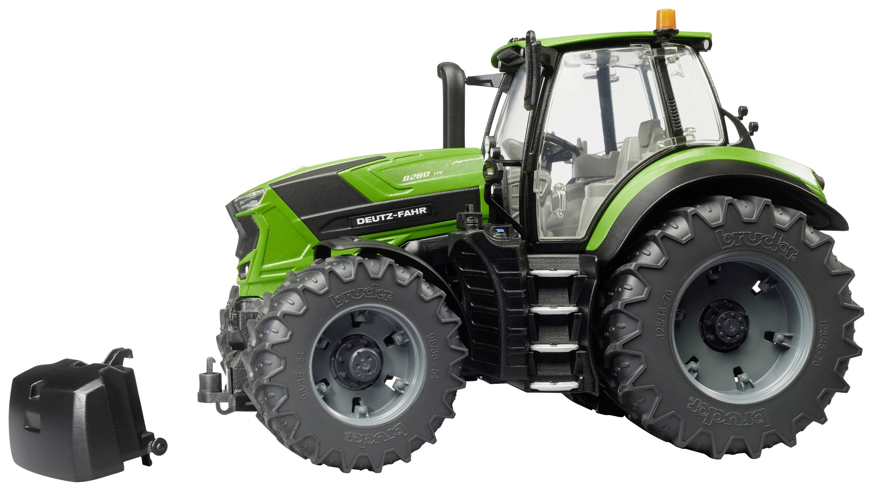 Zelený traktor s velkými pneumatikami stojí z boku na bílé ploše. Vedle traktoru leží odnímatelné přední závaží.