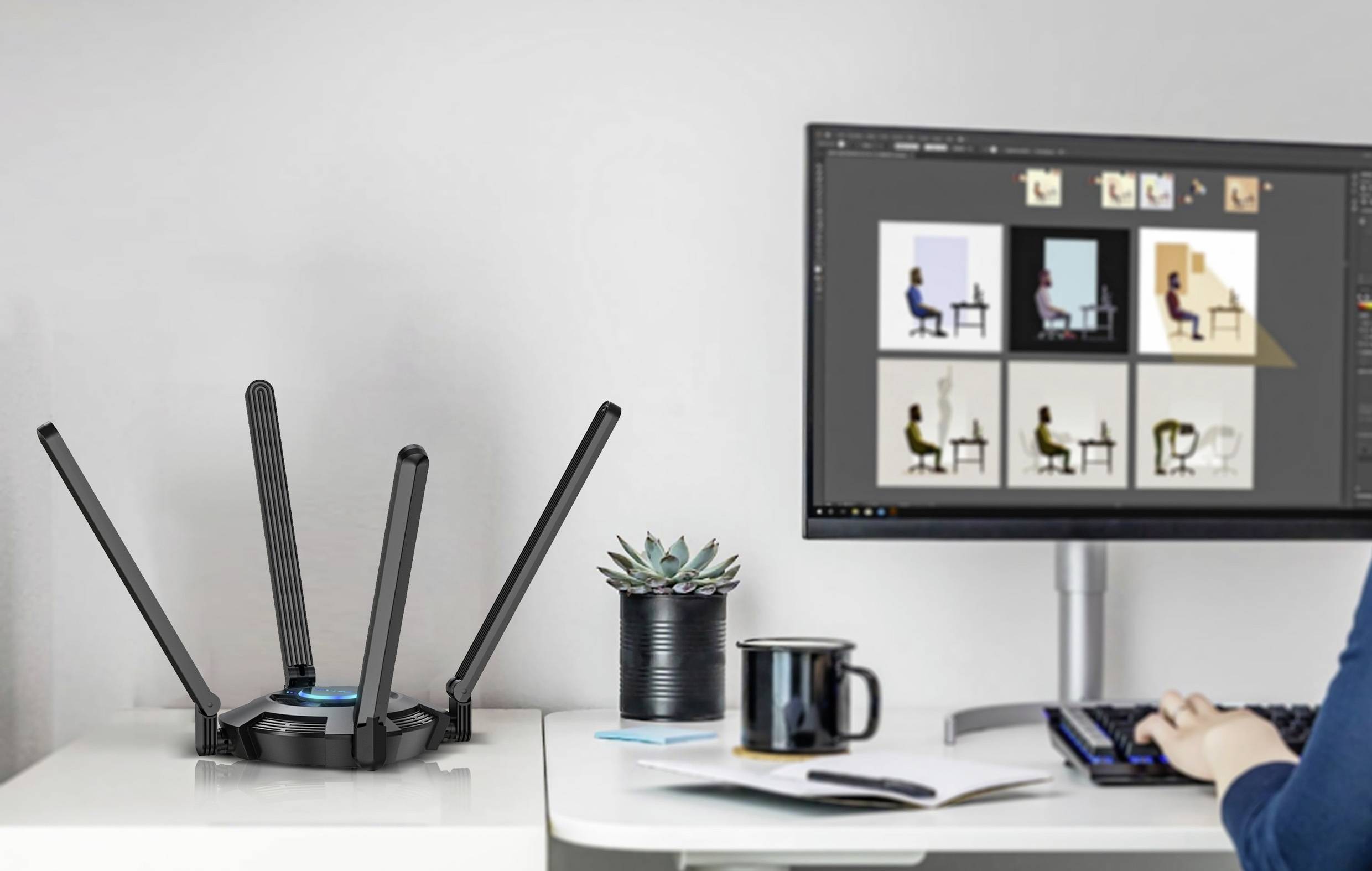 Osoba pracuje na počítači. Na stole stojí Wi-Fi router se čtyřmi anténami, hrnek, pero a rostlina.