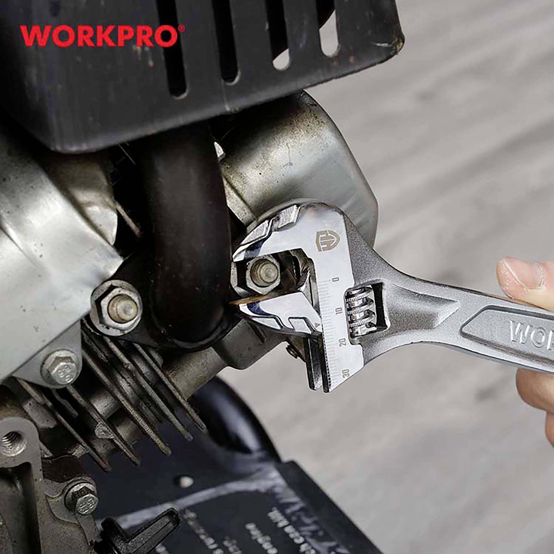 Nastavitelný klíč seřizuje šroub na motoru. Nahoře vlevo je nápis 'WORKPRO' v červené barvě.
