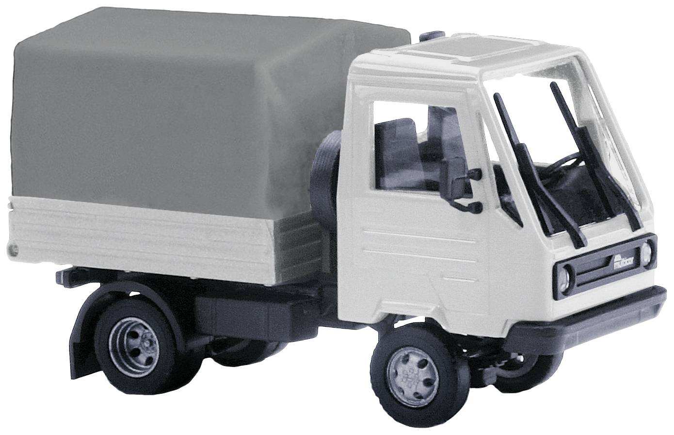 Bílý modelový nákladní automobil s černou střechou a přívěsem stojí na hladkém povrchu.