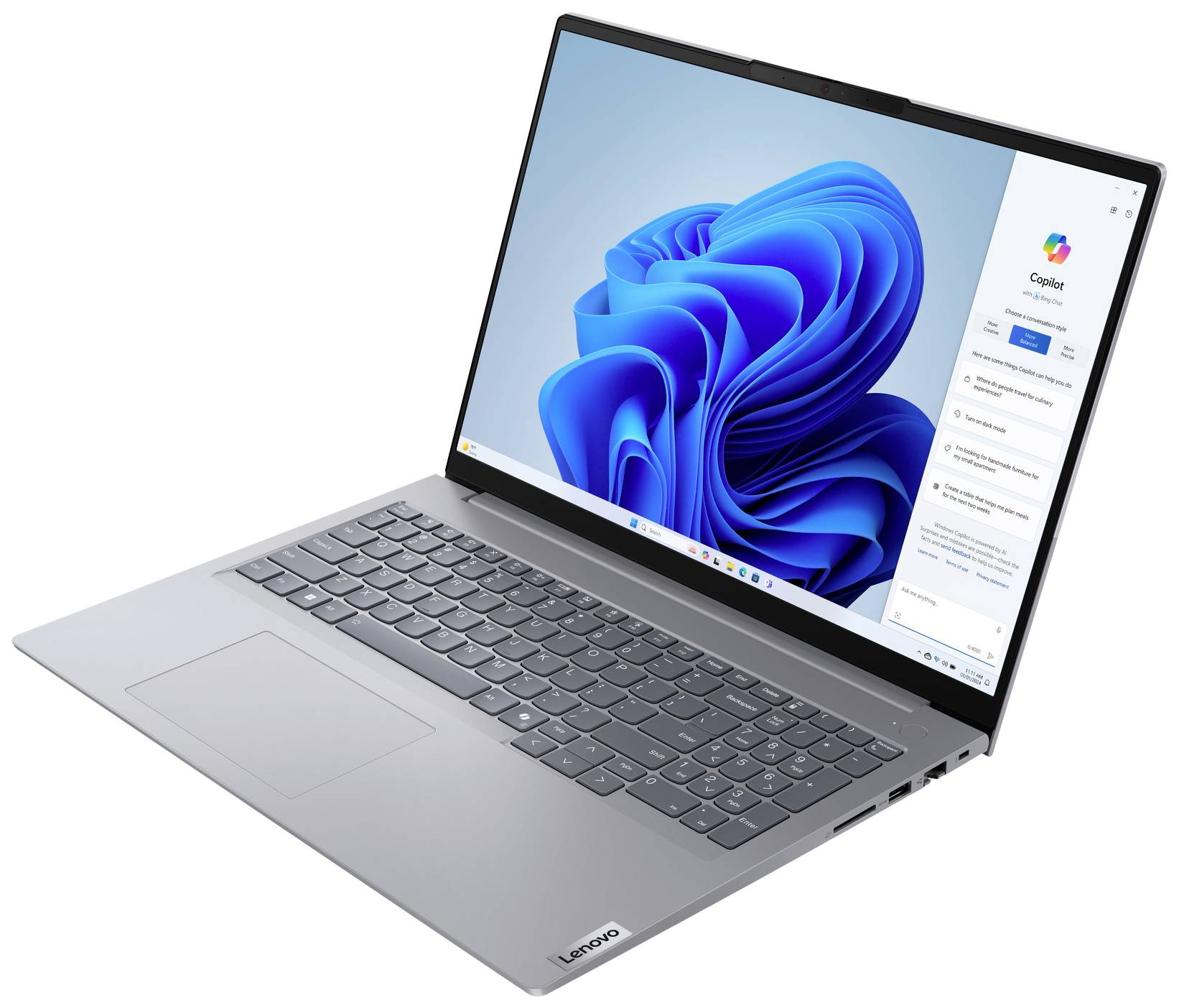 Stříbrný notebook s otevřenou obrazovkou, na které běží Windows 11. Klávesnice a touchpad jsou viditelné.