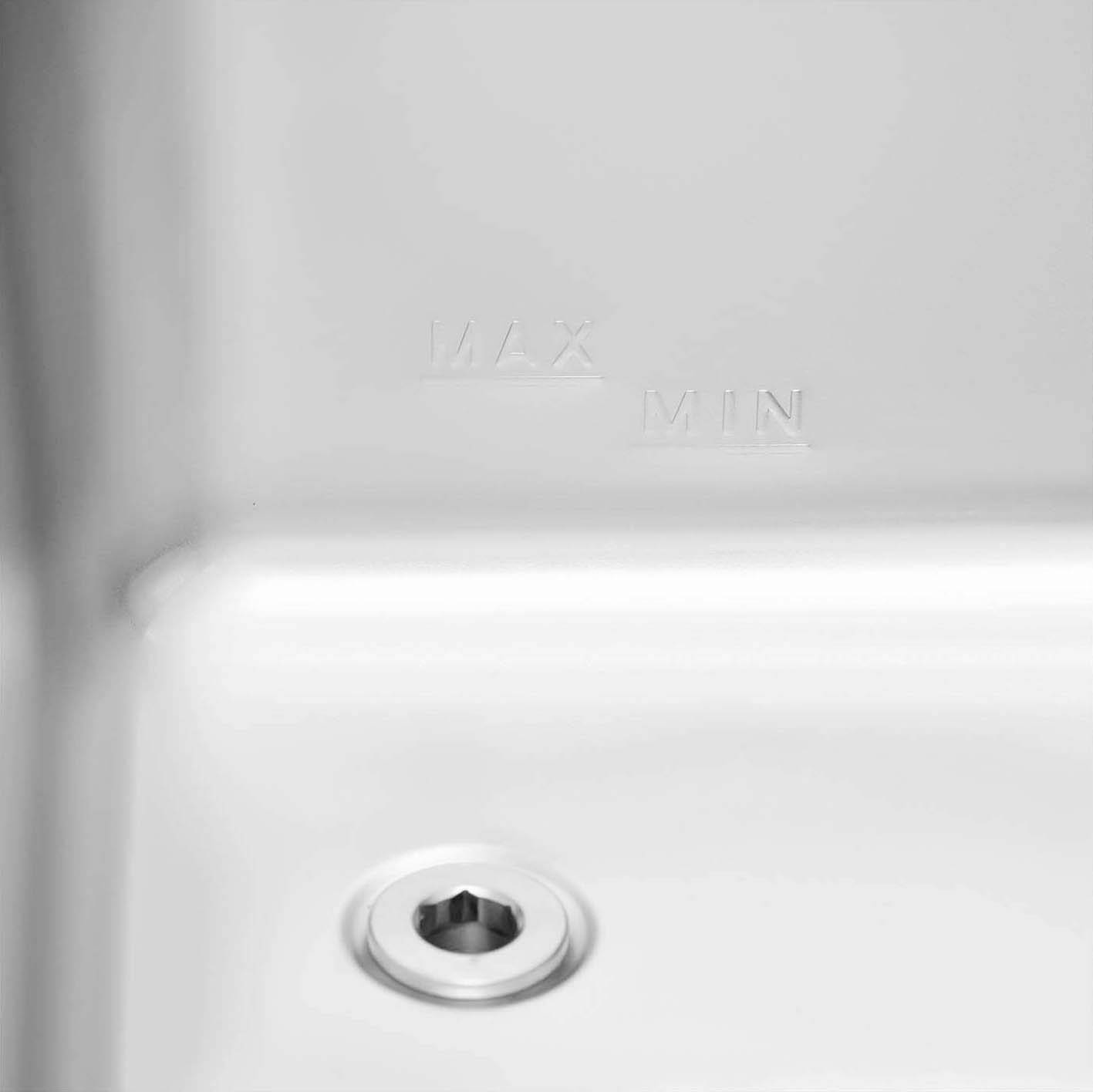 Detailní záběr části zařízení s vyznačenými stupnicemi 'MAX' a 'MIN' a kulatým kovovým dílem, pravděpodobně ventilem.
