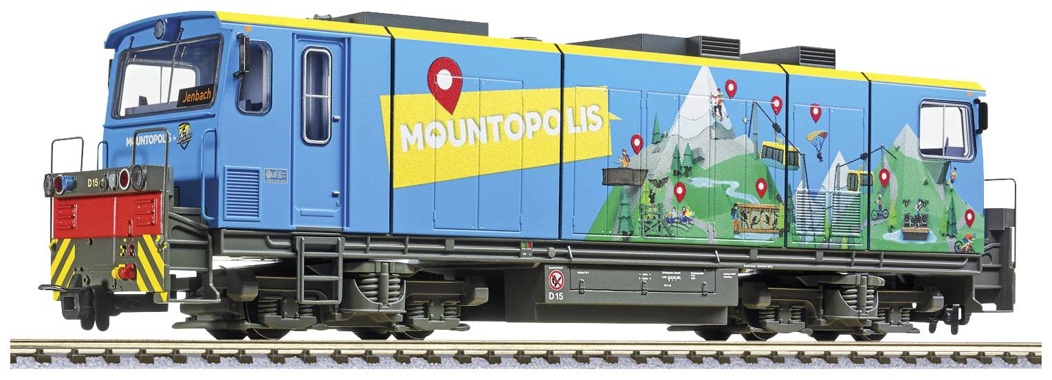 Model vlaku v modro-žlutých barvách s nápisem 'Mountopolis'. Na straně jsou vyobrazeny horské motivy a červené značky.
