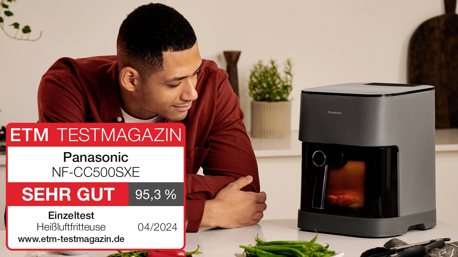 Muž se usmívá na kávový přístroj značky Panasonic. Výsledek testu ukazuje 'VELMI DOBŘE' s hodnocením 95,3 % od testovacího magazínu ETM.