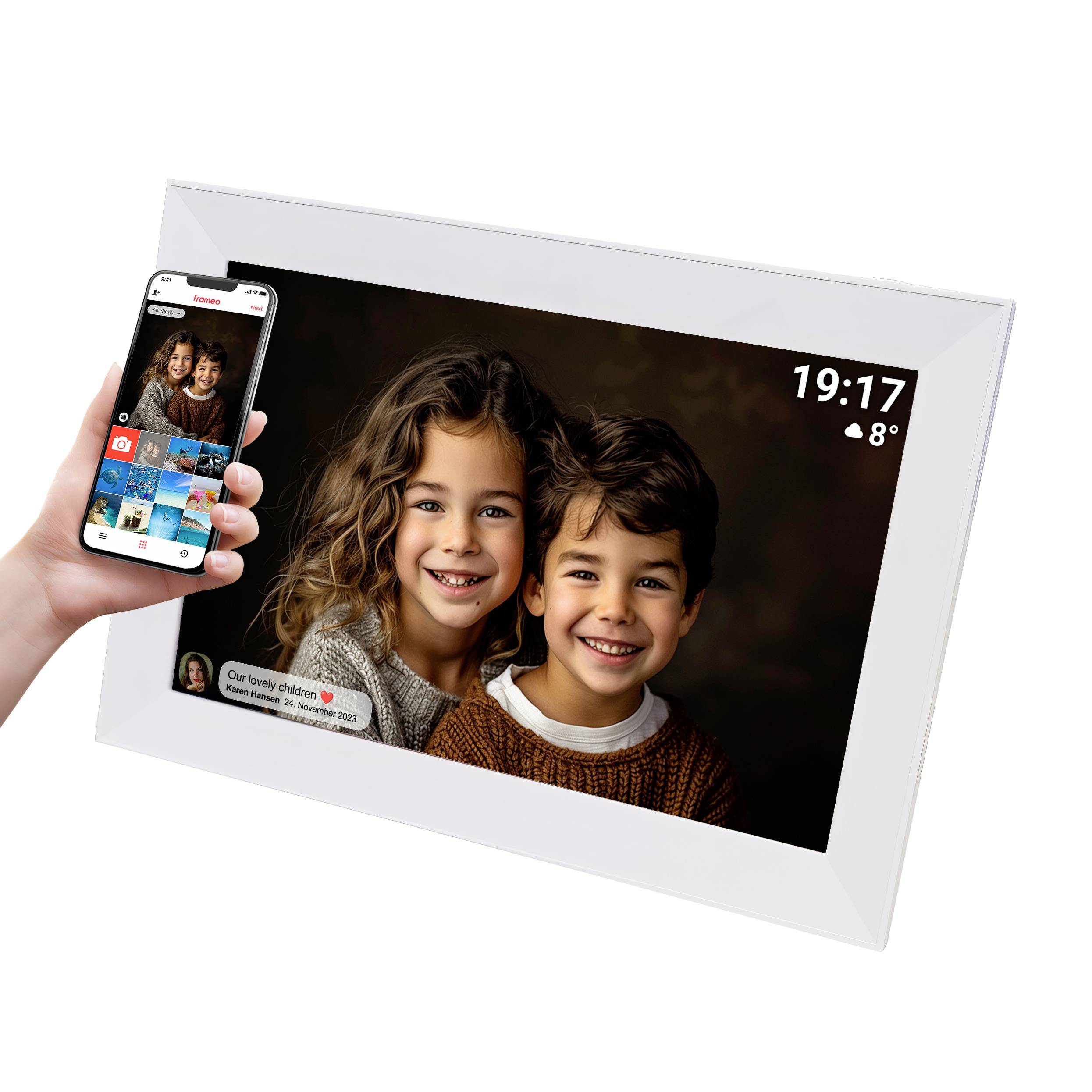 Digitální fotorámeček zobrazuje dva se usmívající děti. Vpravo nahoře je čas a teplota. Ruka drží smartphone pro ovládání.