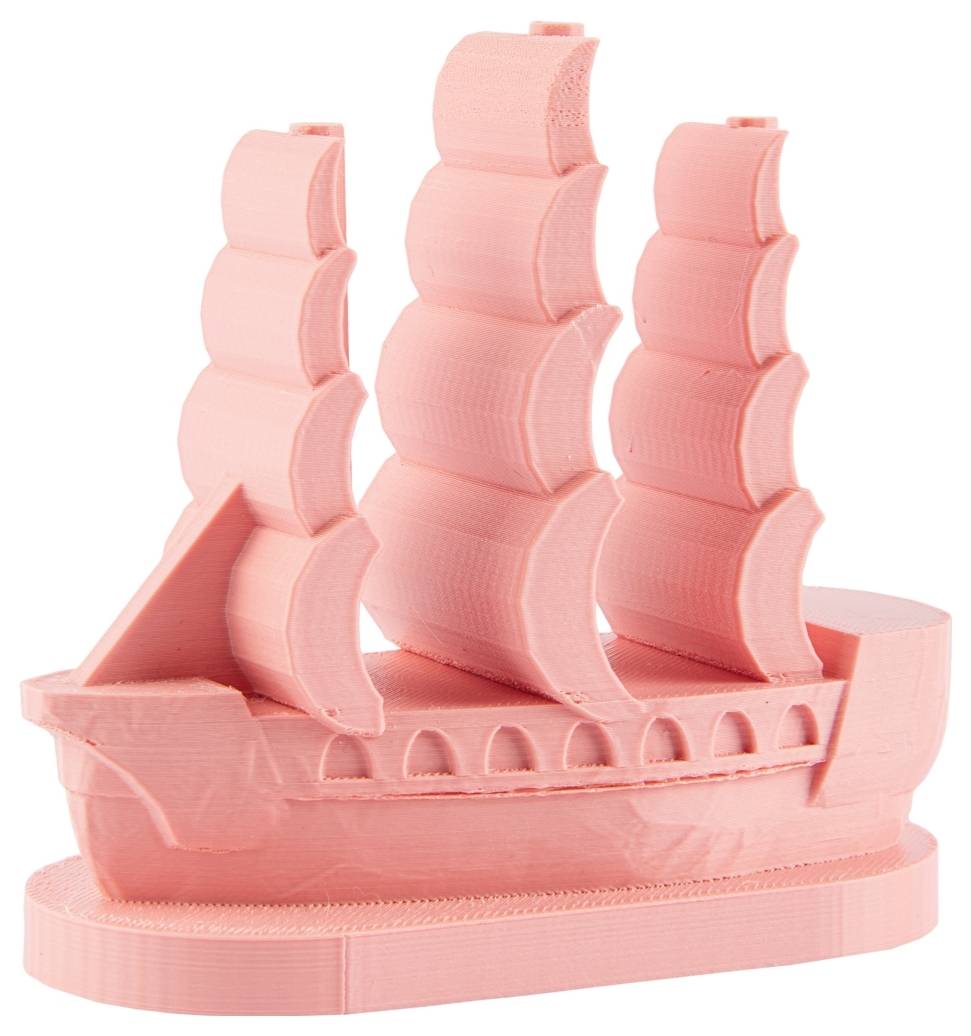 Růžový model lodi se třemi velkými, zahnutými plachtami. Model má jednoduché detaily a stojí vzpřímeně.
