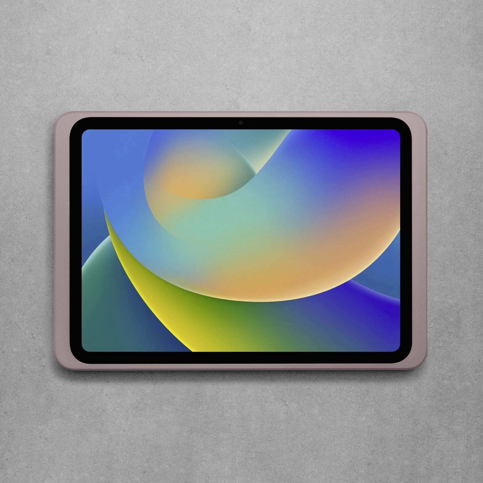 Tablet s barevným, abstraktním pozadím obrazovky leží na šedém povrchu.