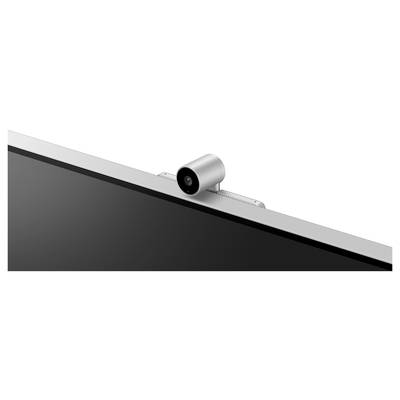 Kamera umístěná nad monitorem počítače. Kamera je stříbrná a válcovitého tvaru.