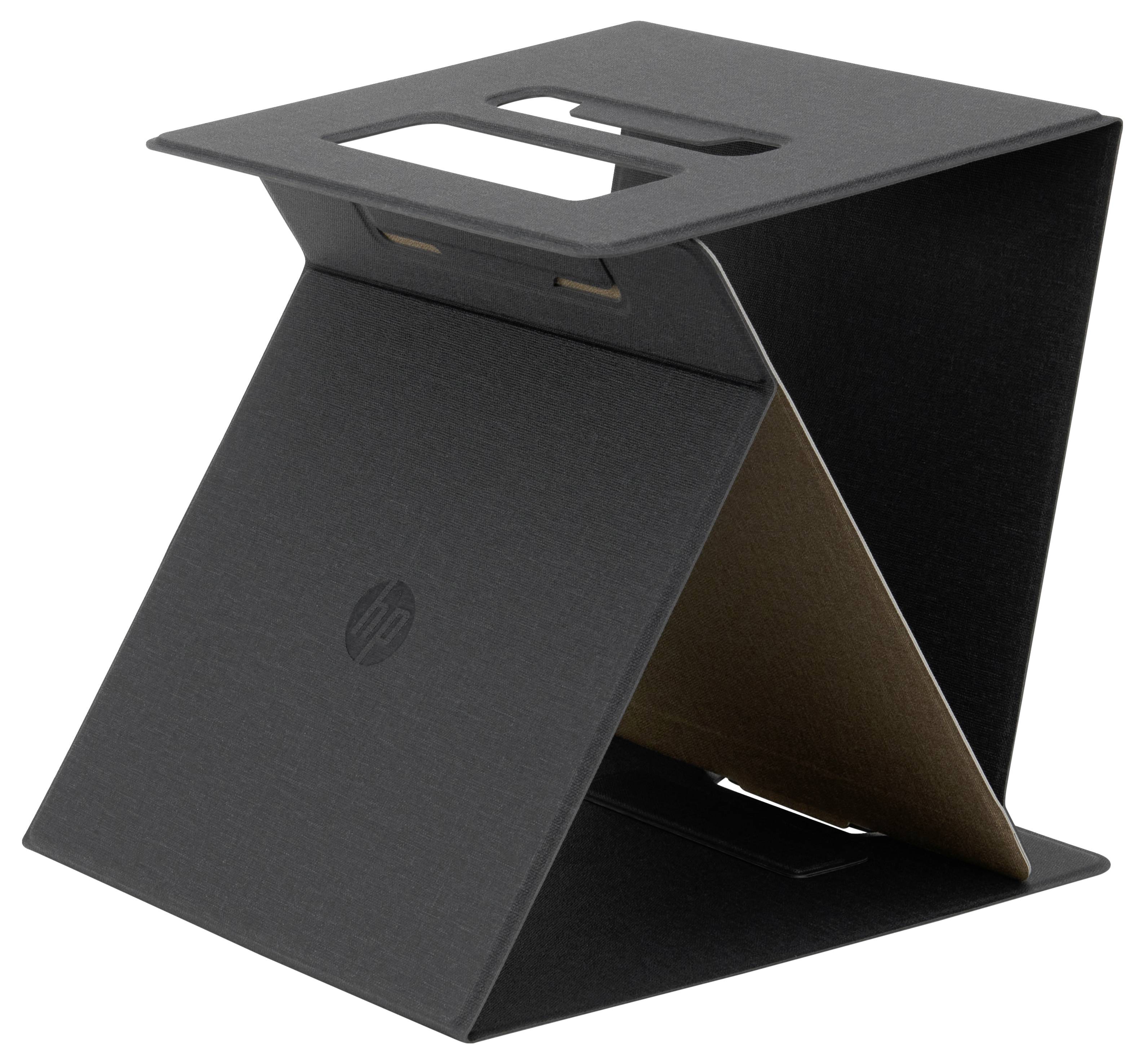 Černý stojan na notebook z kartonu, složený do tvaru připomínajícího pyramidu, s vyříznutými úchyty nahoře.