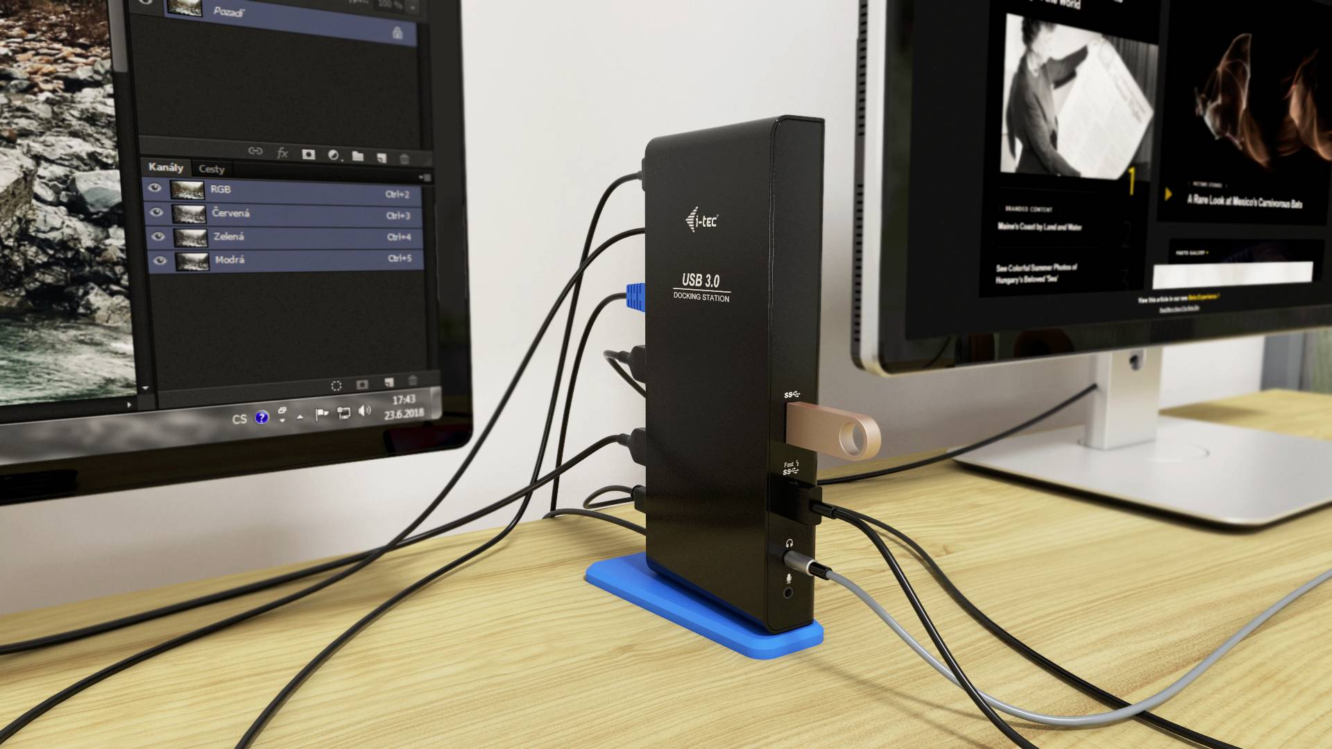 USB 3.0 hub propojuje několik zařízení s počítačem na stole. Dva monitory zobrazují programy, které jsou připojeny přes hub.