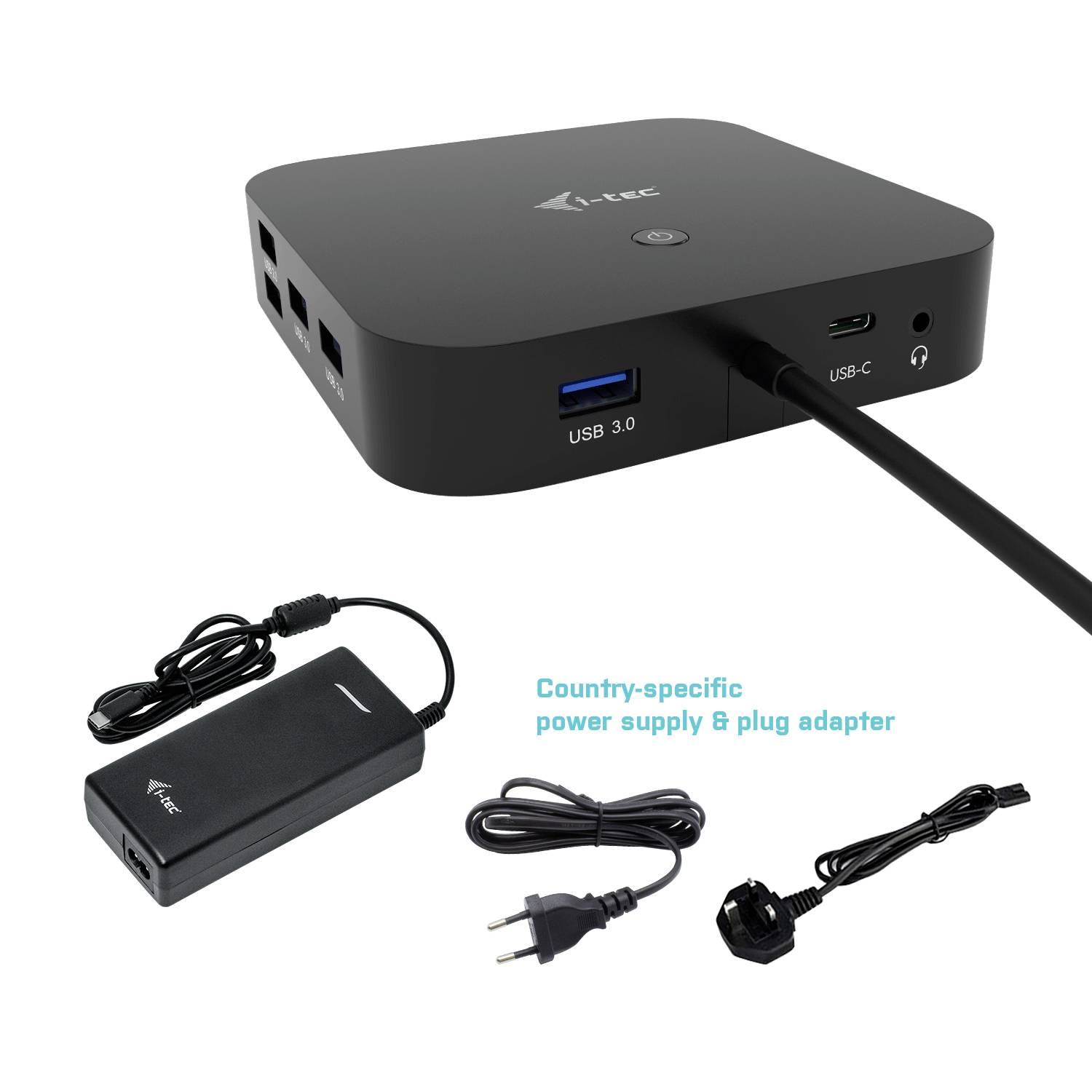 Černý, obdélníkový USB hub s několika porty leží vedle napájecího adaptéru a síťové redukce.