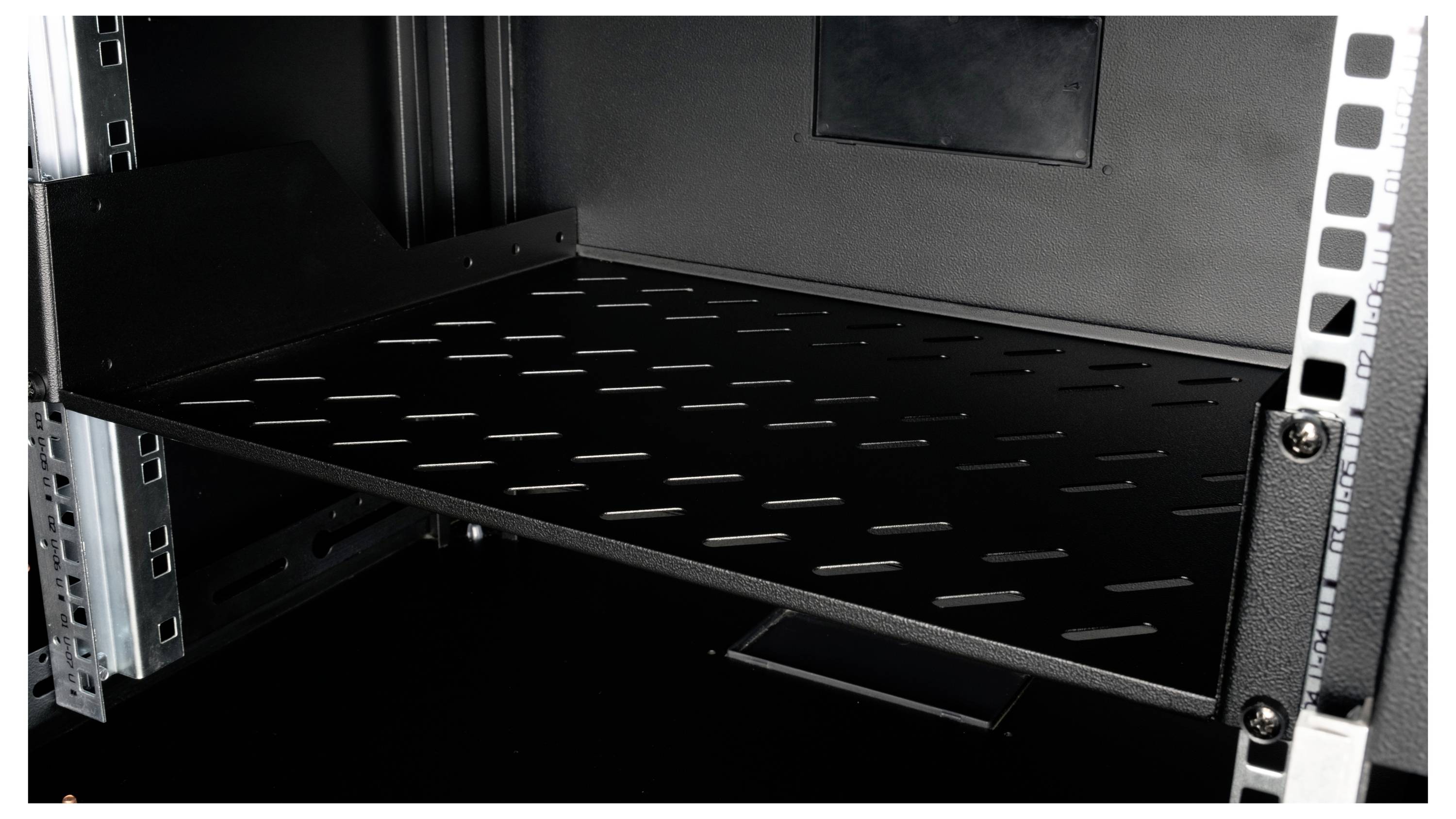 Černý kovový regál v serverové skříni s větraným designem pro cirkulaci vzduchu. Vhodný pro umístění IT komponentů.