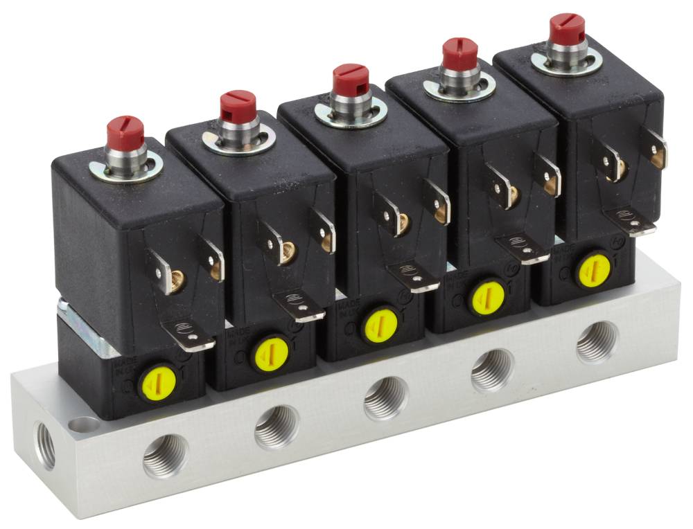 Řada pěti černých elektrických spínačů na kovovém kolejnicovém pásu, každý s červeným tlačítkem a žlutým označením.