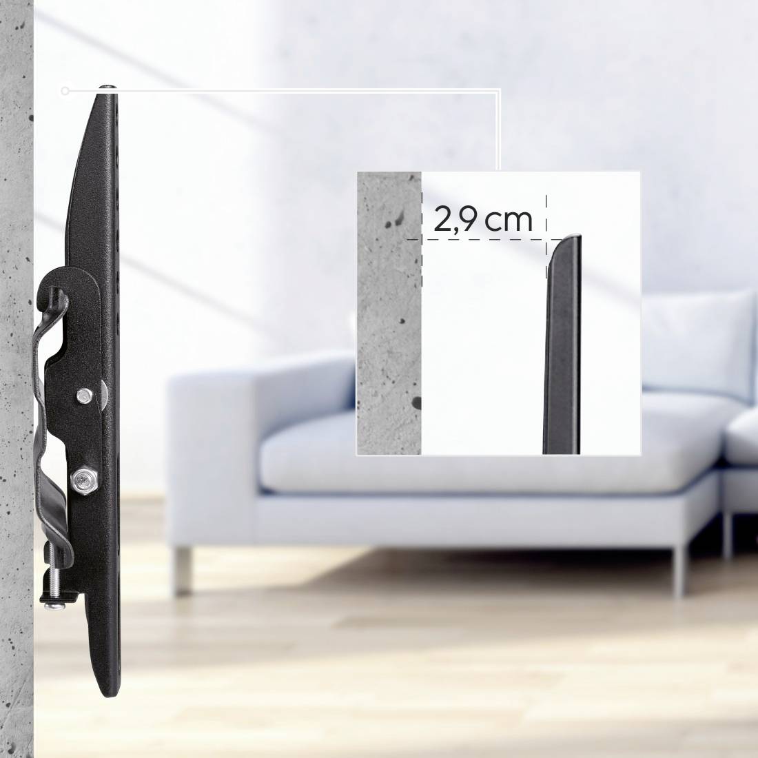 Plochý TV držák na stěně vyčnívá 2,9 cm. V pozadí je gauč v světlém obývacím pokoji.