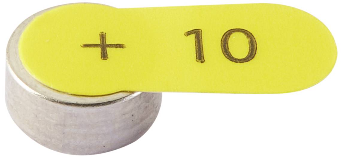Na stříbrném válci leží žlutá numerická značka potištěná '+10'.
