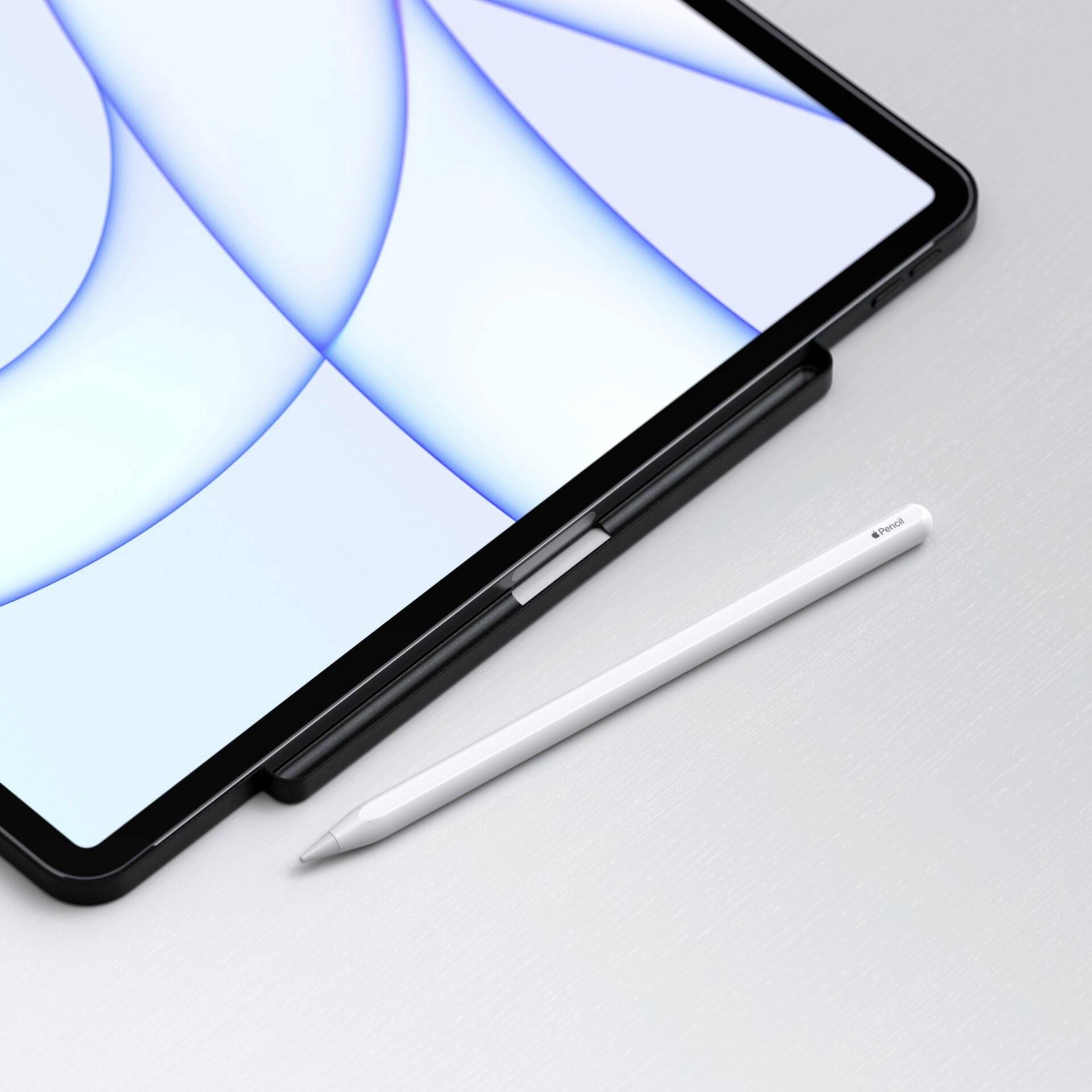 Tablet s bílým perem vedle něj leží na šedém stole. Displej zobrazuje abstraktní světle modný vzor.