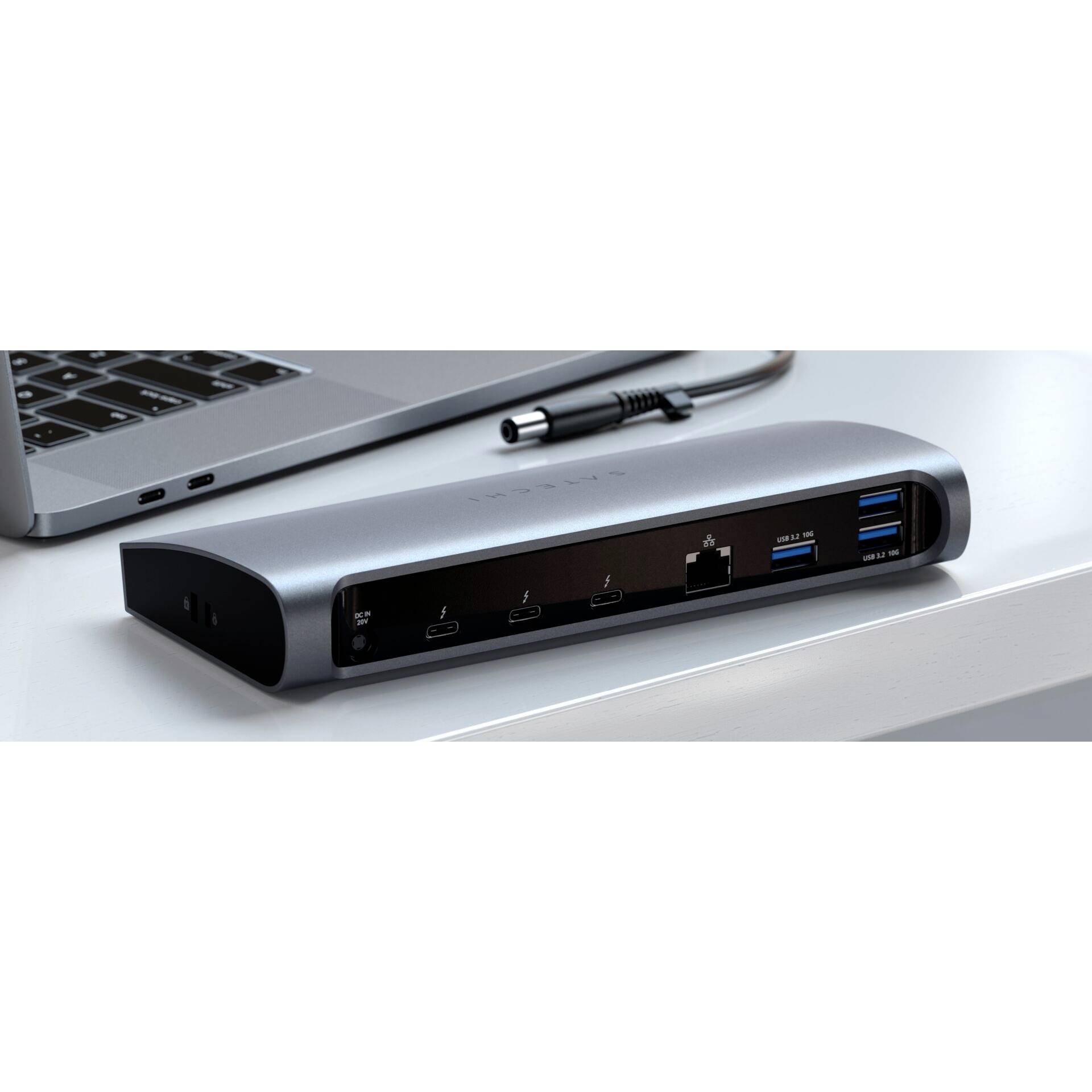 Černý modul dokovací stanice počítače na stole. Propojuje laptop nalevo a nabízí několik USB, HDMI a ethernetových portů.