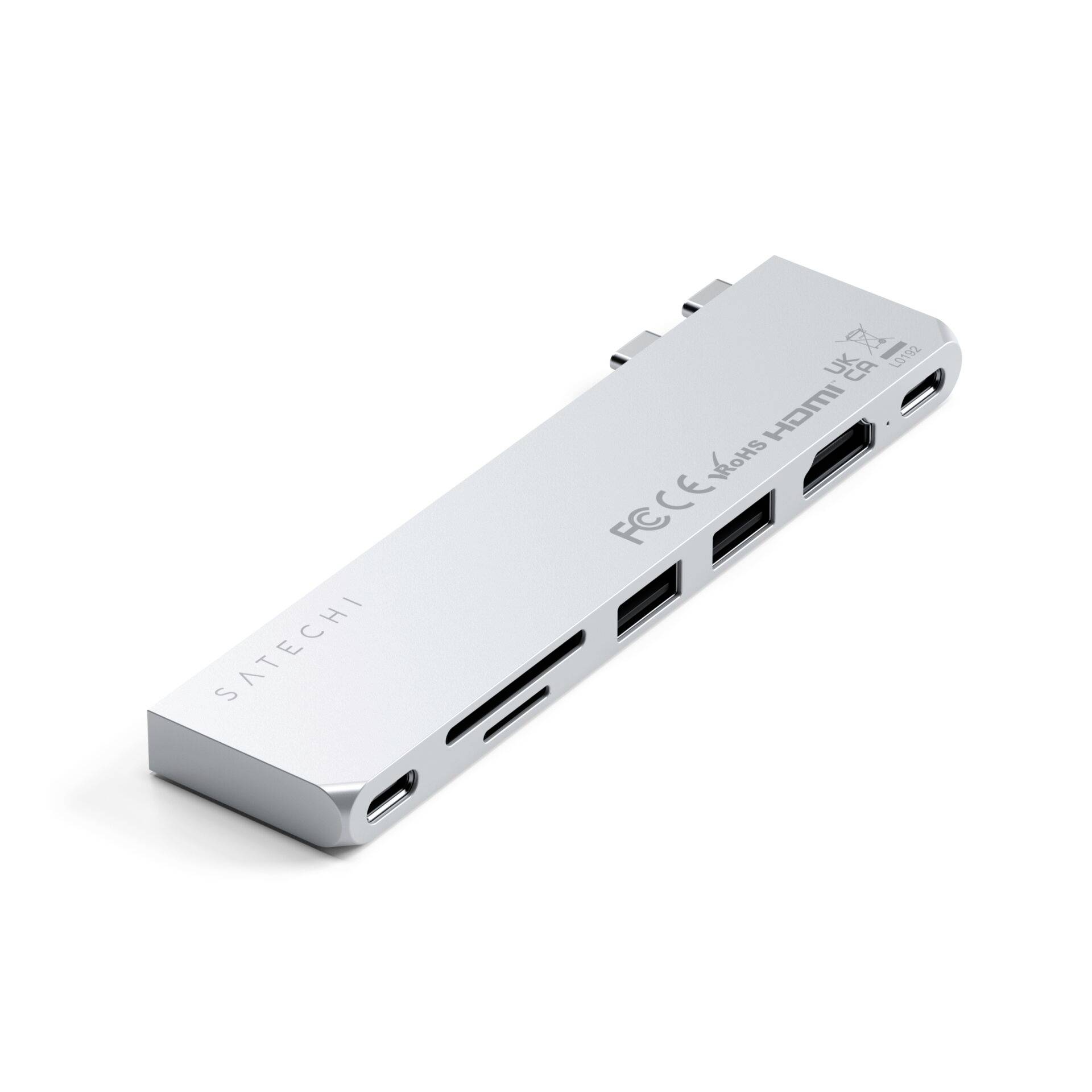 Stříbrný USB-C hub s více porty, včetně HDMI, USB a slotů pro SD karty. Na povrchu značka 'SATECHI'.