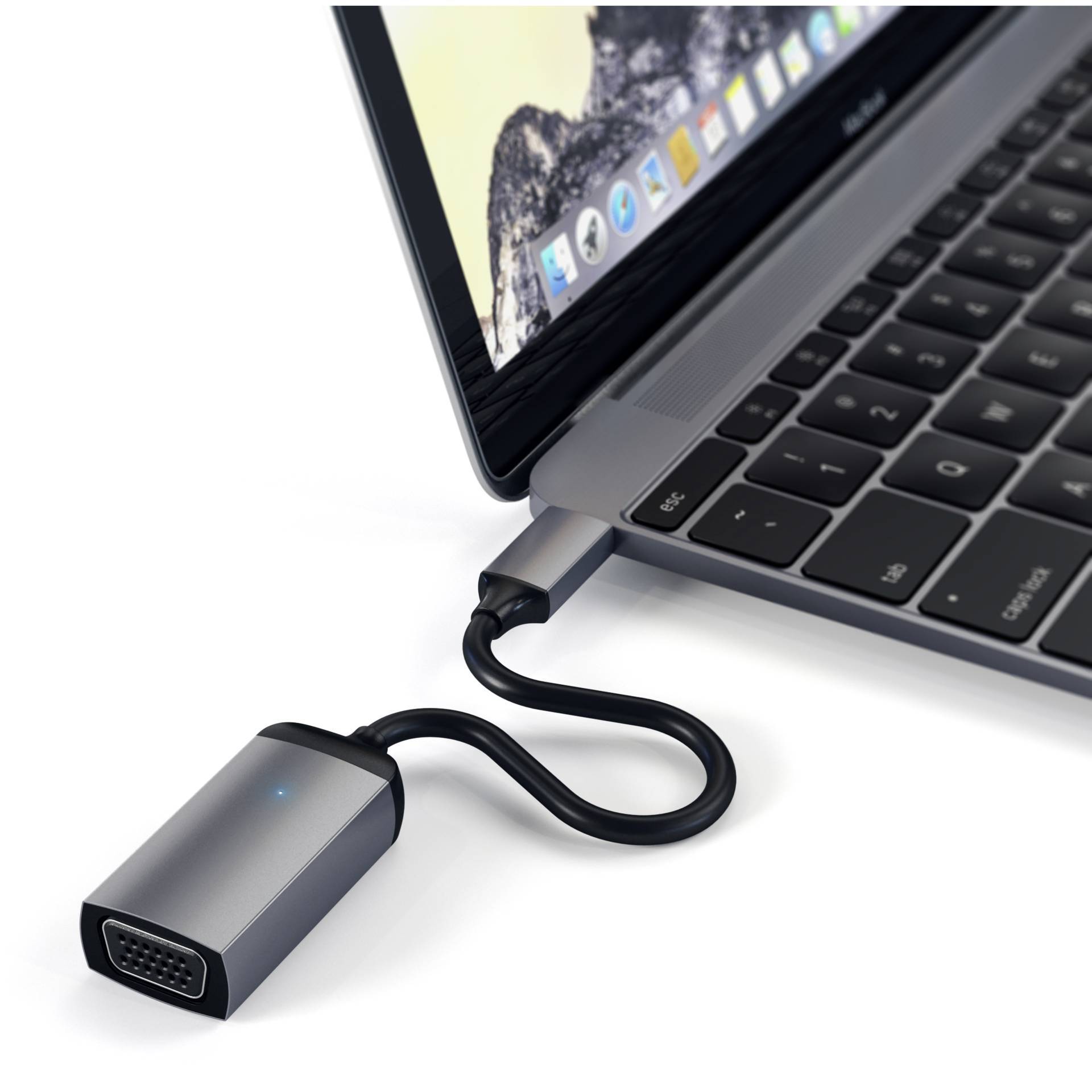 Notebook s připojeným adaptérem, který převádí USB-C port na VGA port. Na obrazovce je zobrazen plocha.