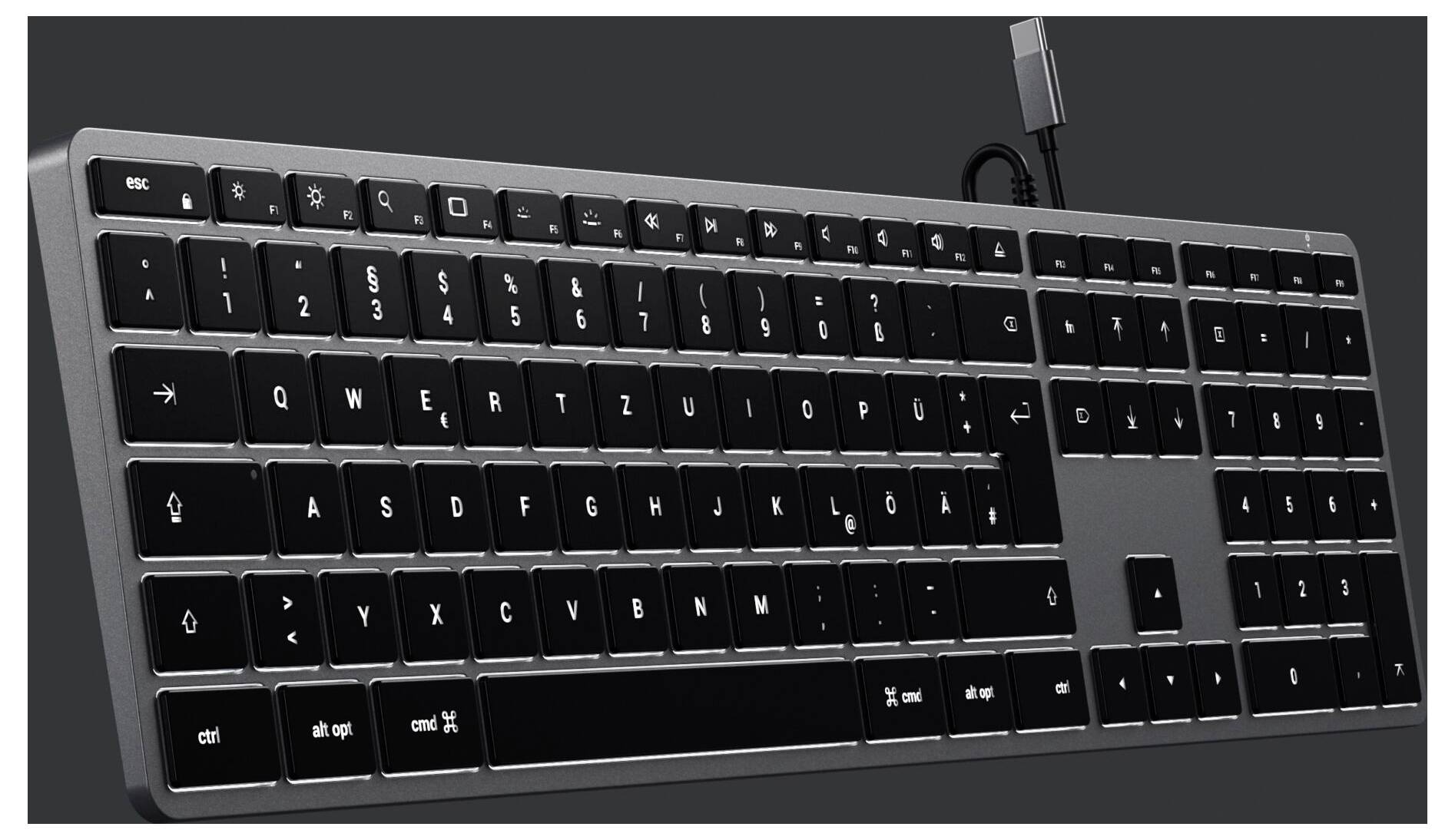 Černá počítačová klávesnice s QWERTZ rozložením a stříbrným rámečkem. Nahoře vpravo je připojen USB kabel.