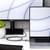 Laptop a monitor na bílém psacím stole; oba zobrazují podobný bílo-modrý vzor na svých obrazovkách.
