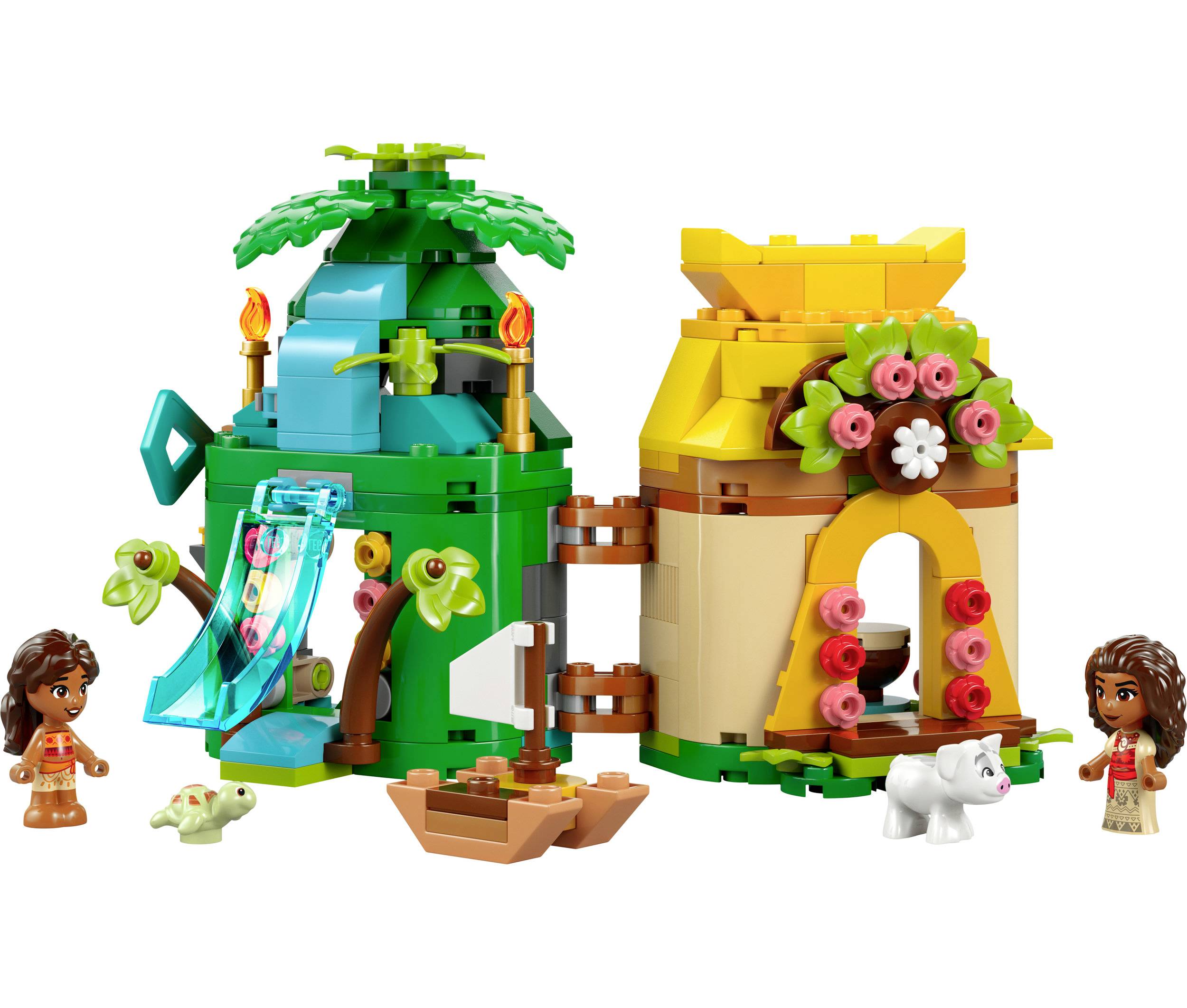 Dvě mini figurky před barevnými, stromovitými LEGO domy s klouzačkou a květinami, doprovázené malou želvou a bílým psem.