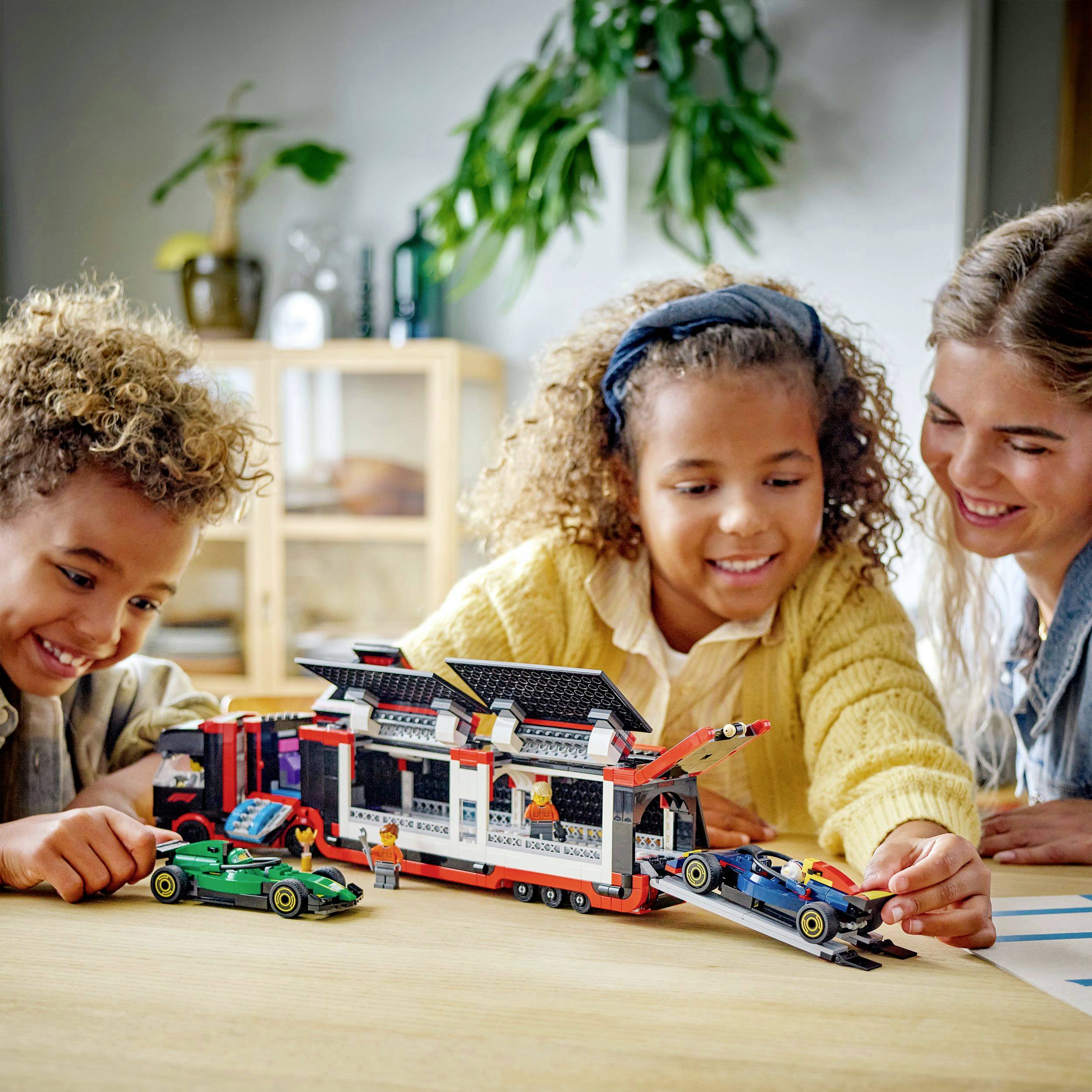 Děti a žena společně hrají si s Lego stavebnicí u stolu v obývacím pokoji. V pozadí jsou viditelné rostliny.