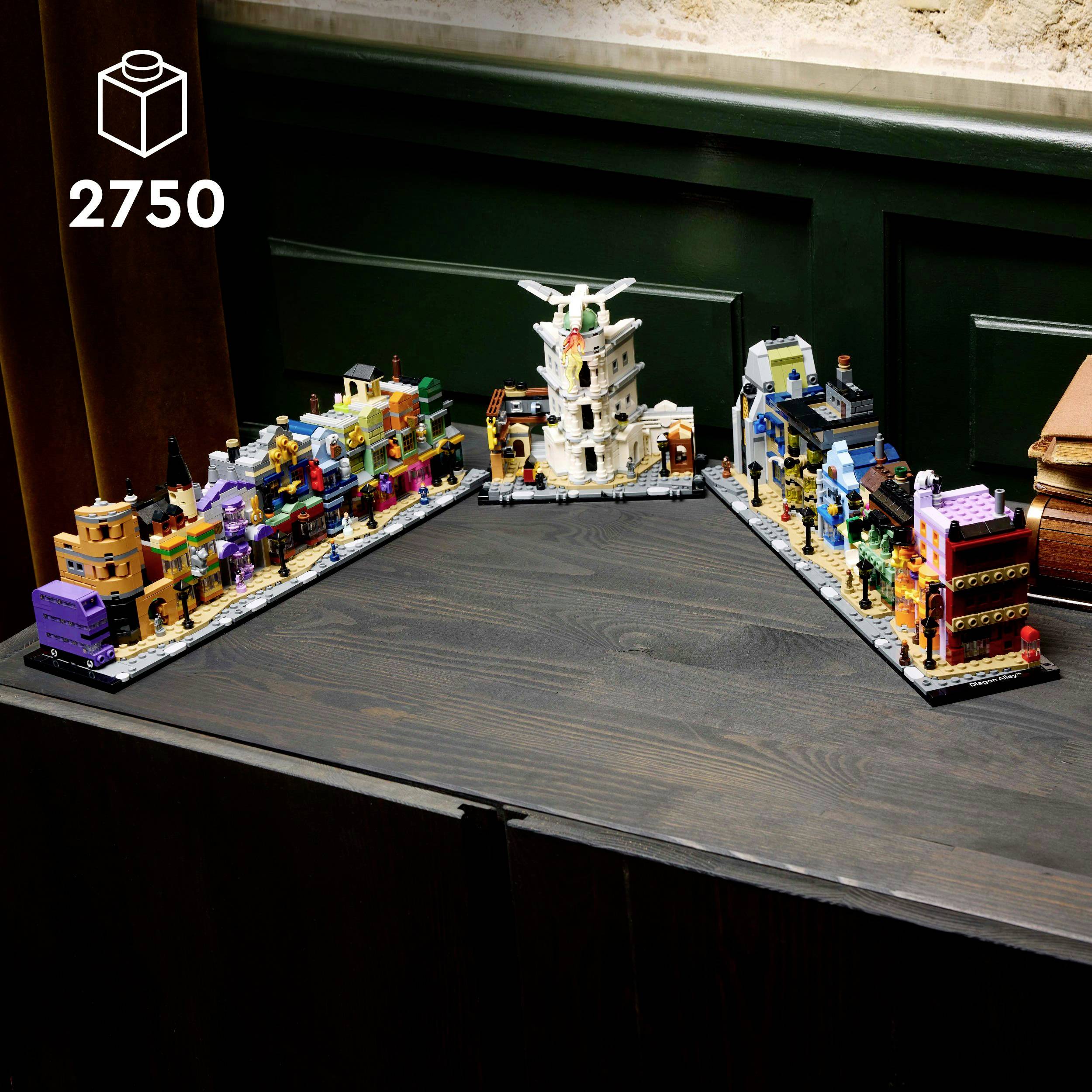 Diorama z barevných stavebních kostek zobrazuje miniaturní město s věžemi, budovami a sochami na dřevěném stole. Vlevo nahoře je napsáno '2750'.