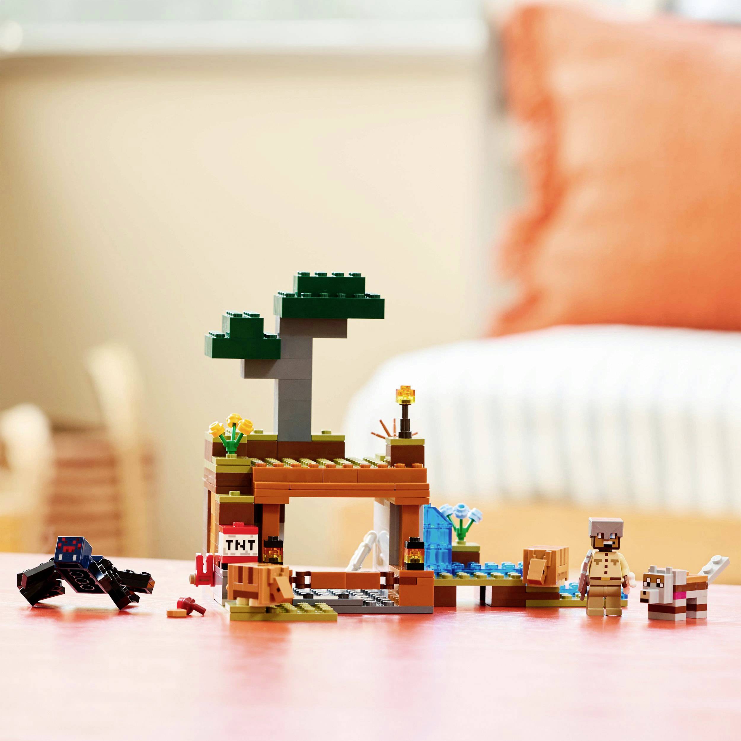 Lego sada s tématem Minecraftu zobrazuje krajinu se stromem, figurkou a modelem Creepera na stole.