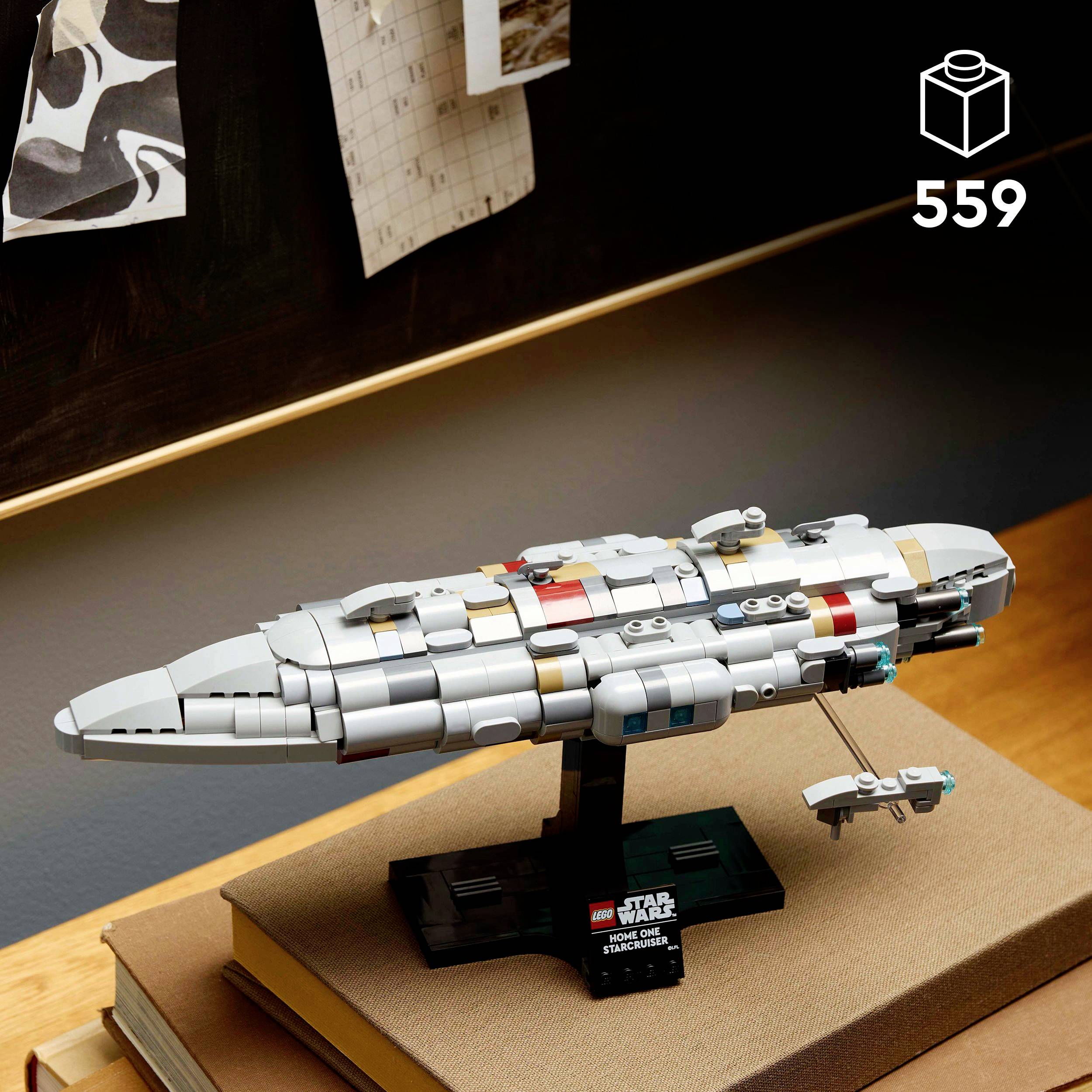 Stavebnice Lego vesmírné lodi na stole, v pozadí tabule s visícími papíry. Viditelné číslo 559 a symbol kostky.