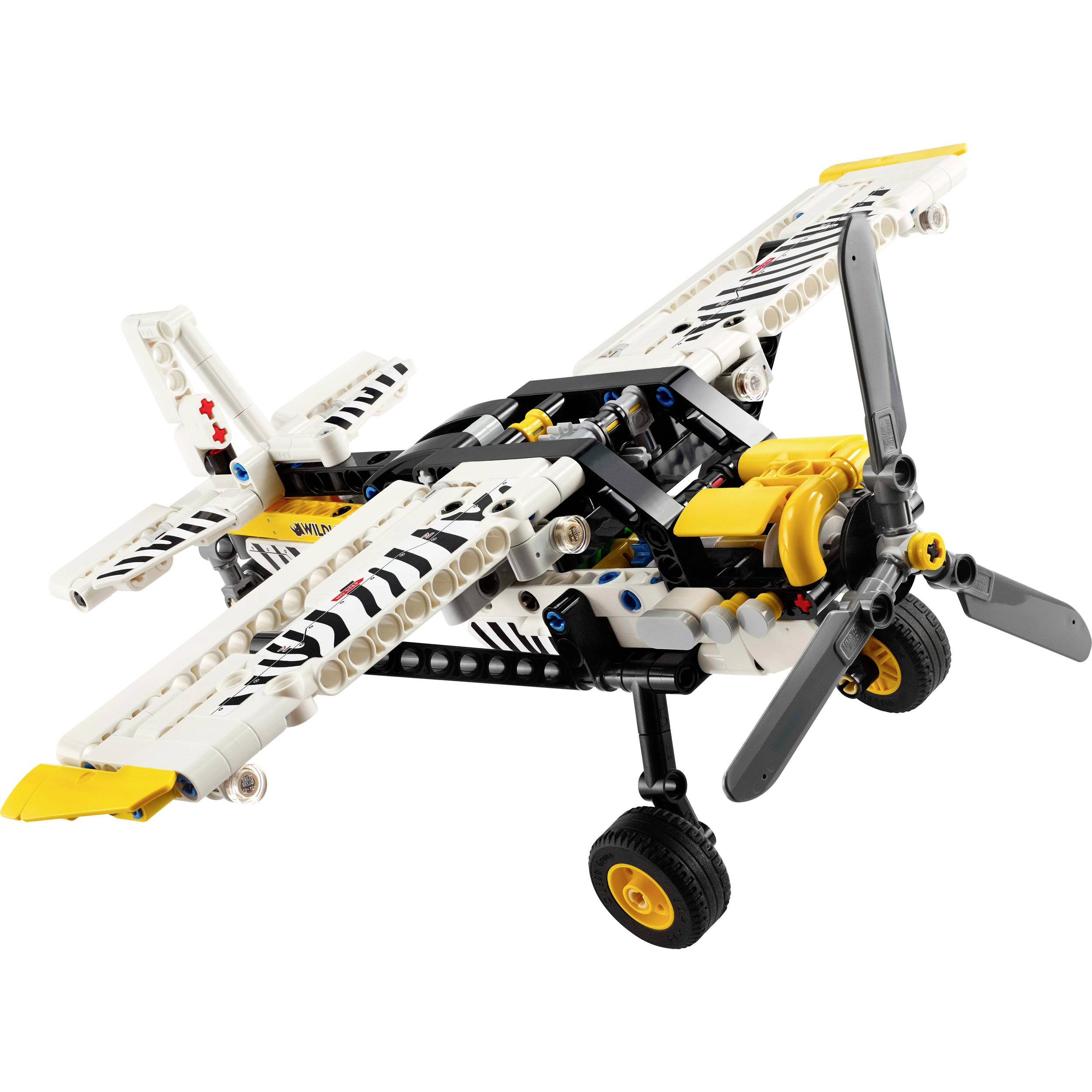 Malé modelové letadlo z dílů LEGO Technic v bílé, černé a žluté barvě s pohyblivými vrtulemi a koly.