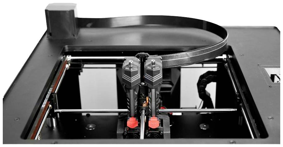 3D tiskárna při práci, zobrazující vedení filamentu a mechanismus tiskové hlavy. Detail technologie v průběhu tisku.