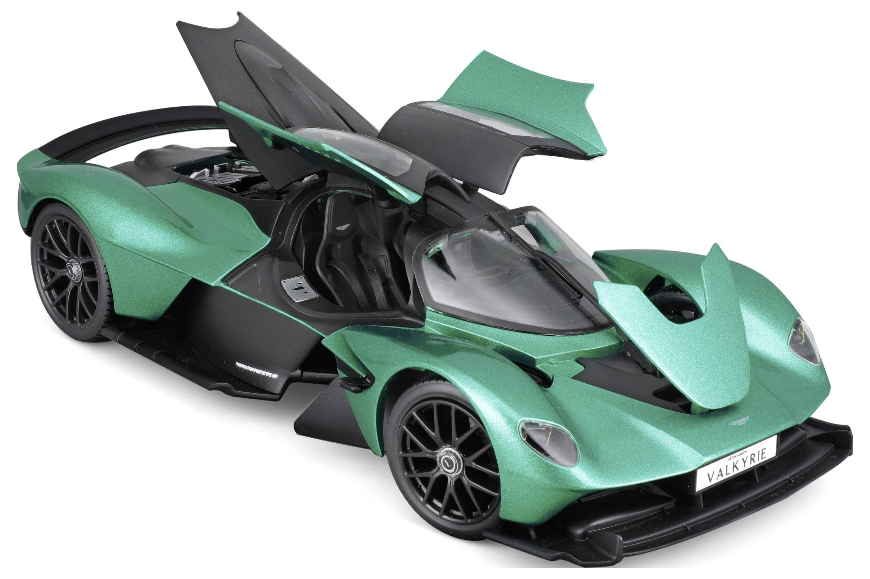Zelené kovově lesklé modelové auto s křídlovými dveřmi je otevřené a ukazuje svůj interiér. Na poznávací značce je napsáno 'Valkyrie'.